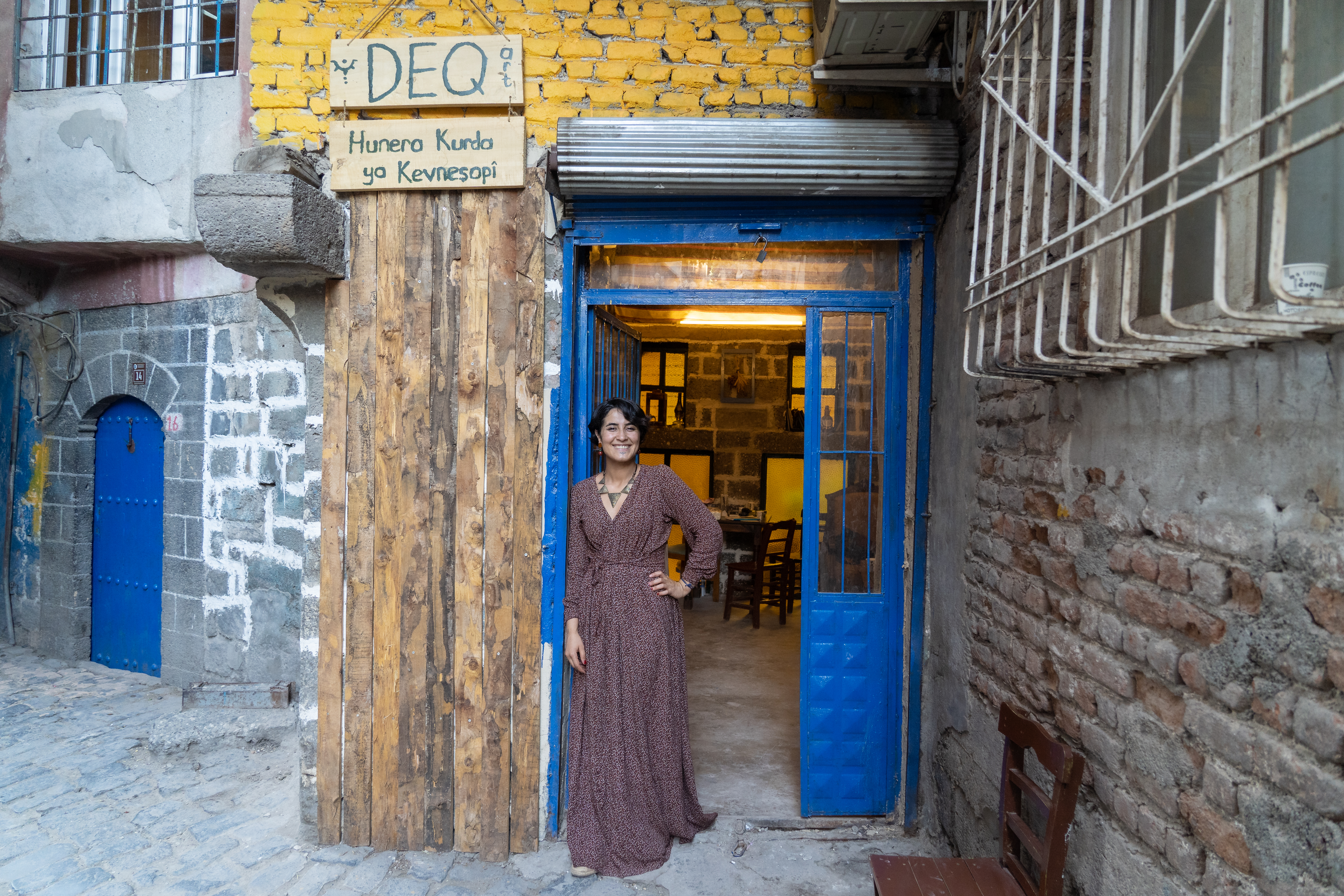 A photo of Fatê Temel standing outside her Deq studio in Diyarbakır’s historic Sur district, which she opened in November last year.