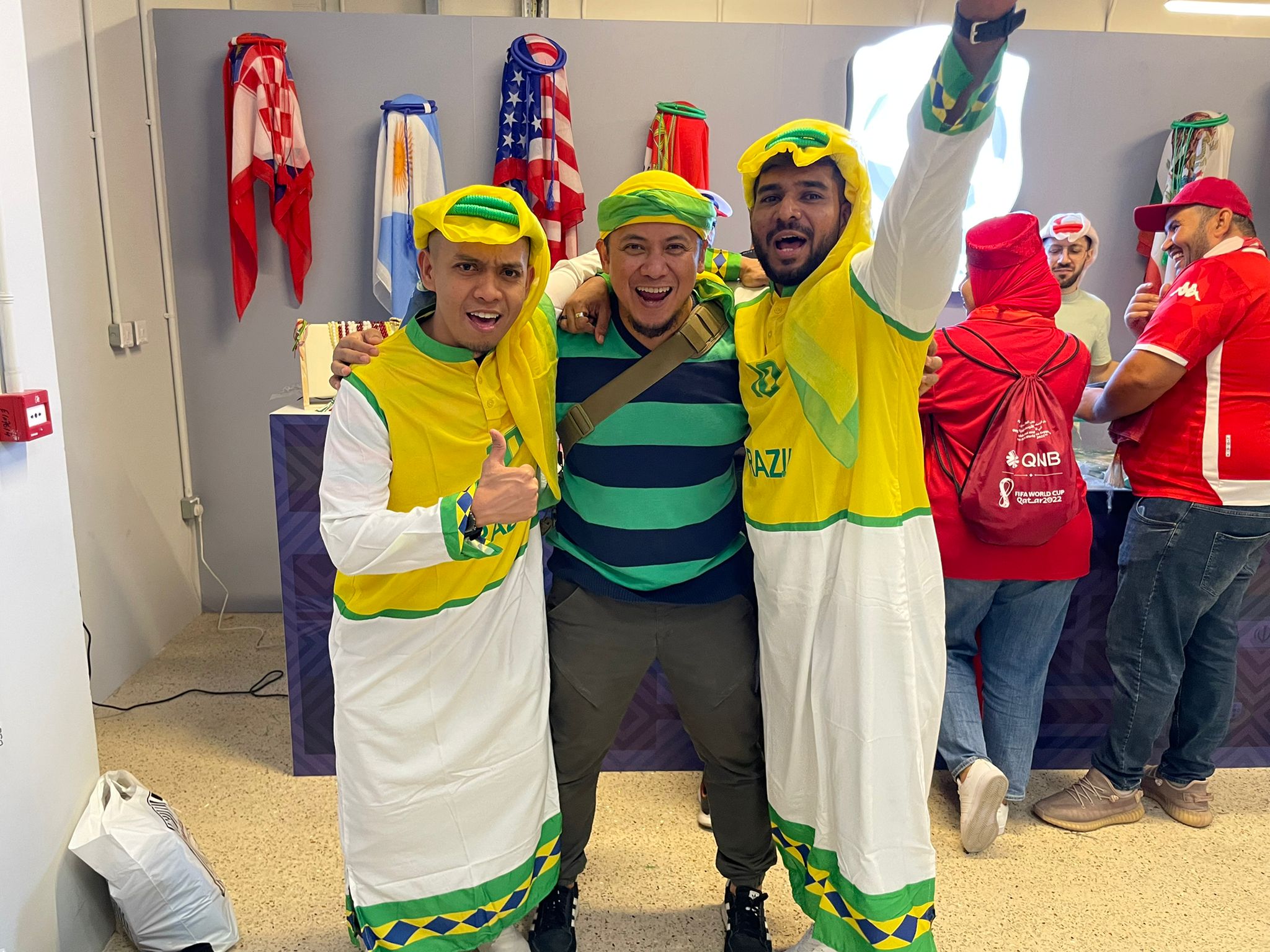 Football fans pose with a customised Brazilian version of a ghutra and other accessories at a Qatari sports shop