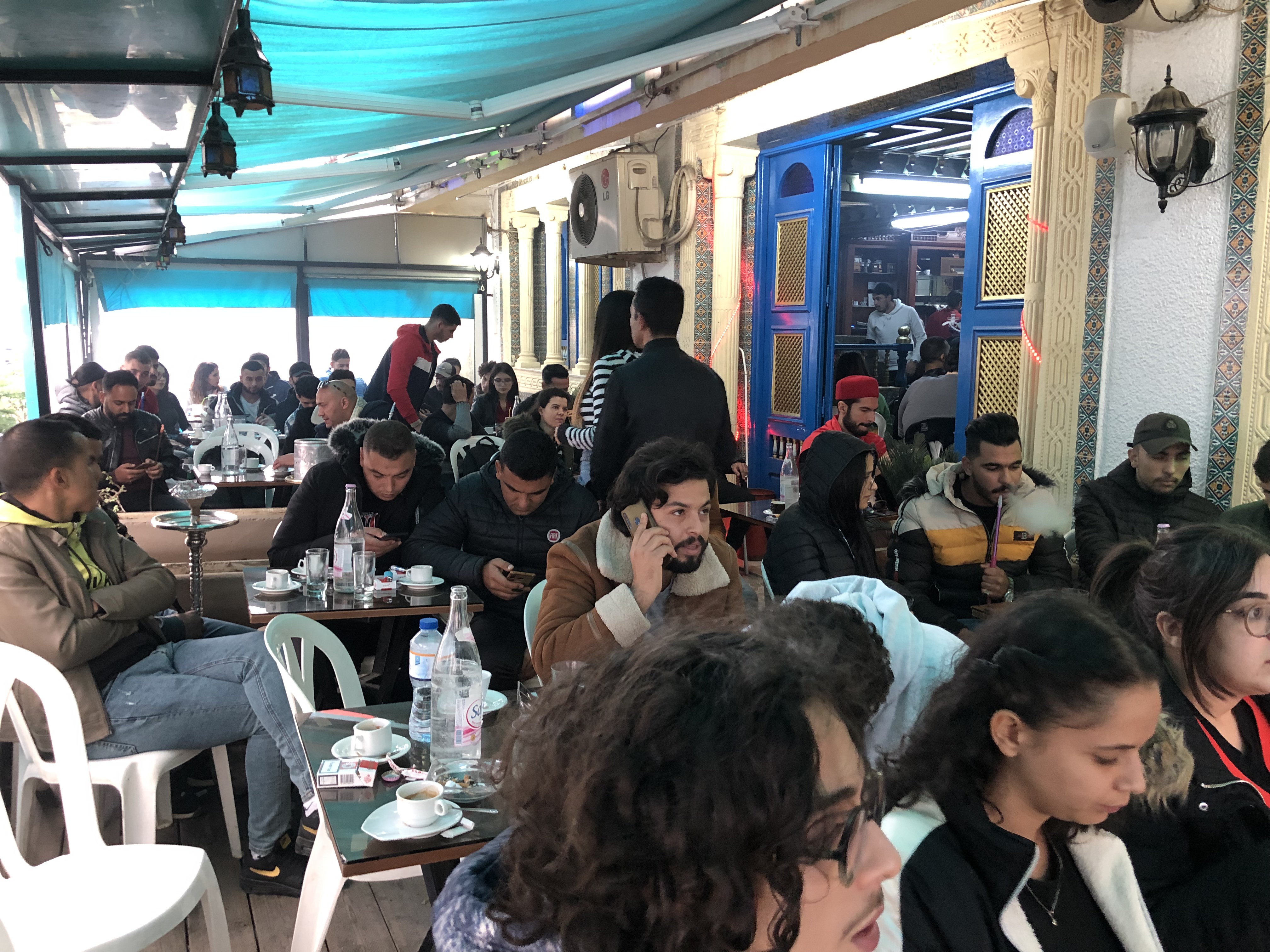 An Arabic tea house in Tunis filled with customers watching the Tunisia vs Denmark World Cup match [Elizia Volkmann/Al Jazeera]