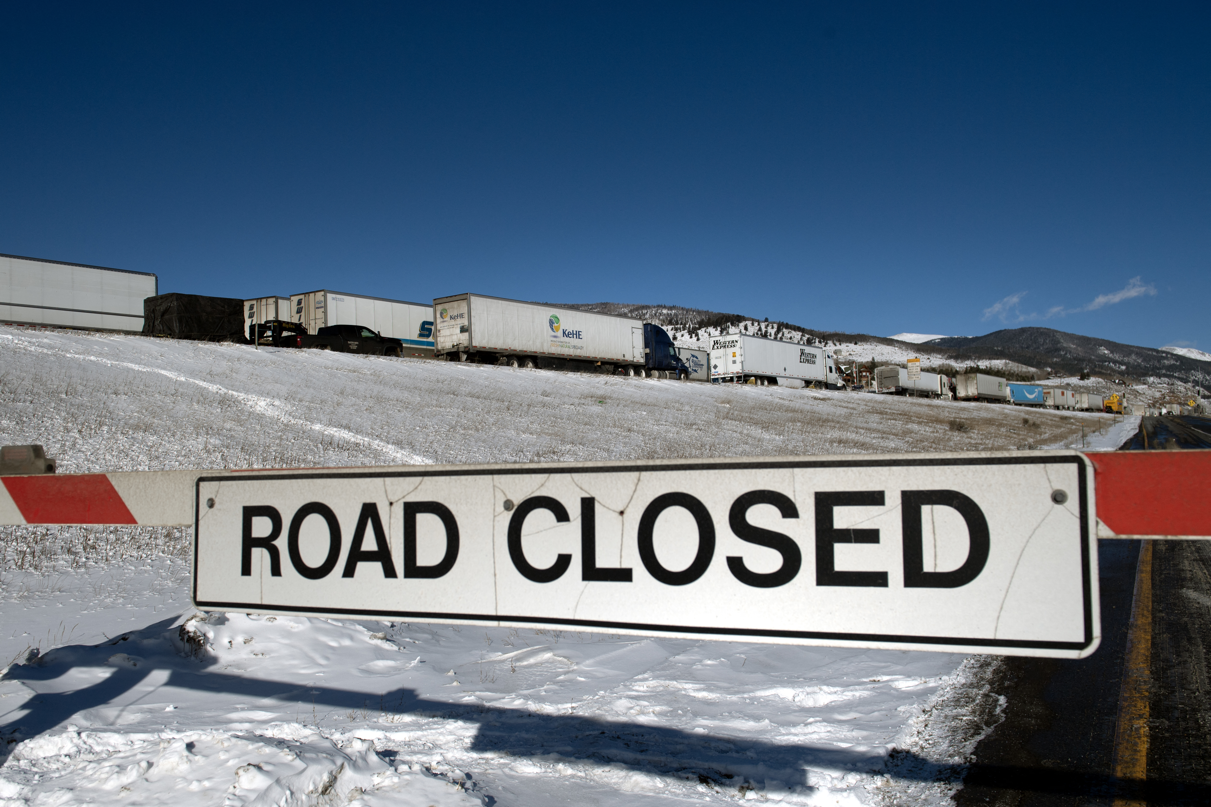 Semitrucks line up in the eastbound land on I-70, which was closed due to extreme winter