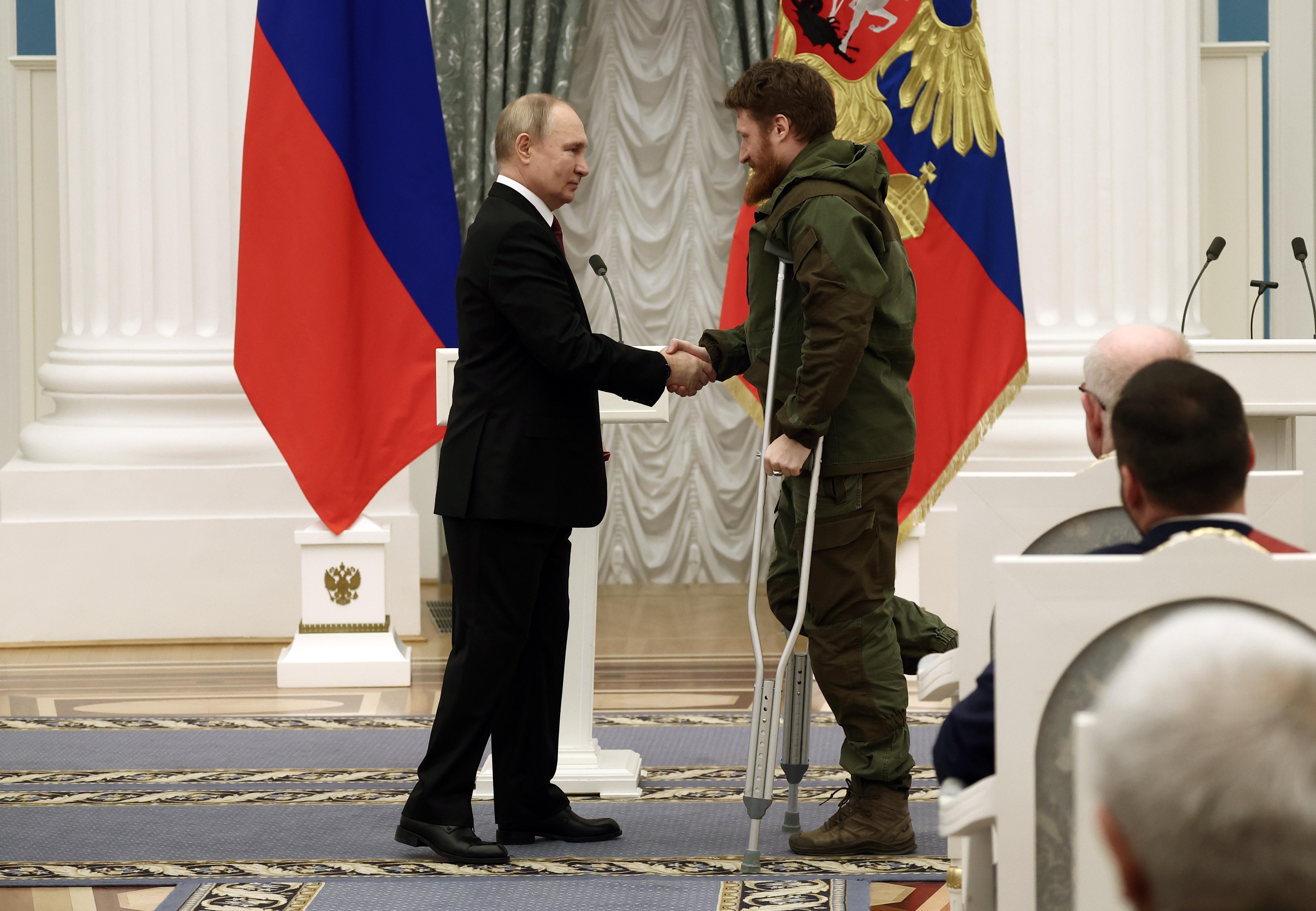 Russian President Vladimir Putin (L) awards founder of the WarGonzo project Semyon Pegov