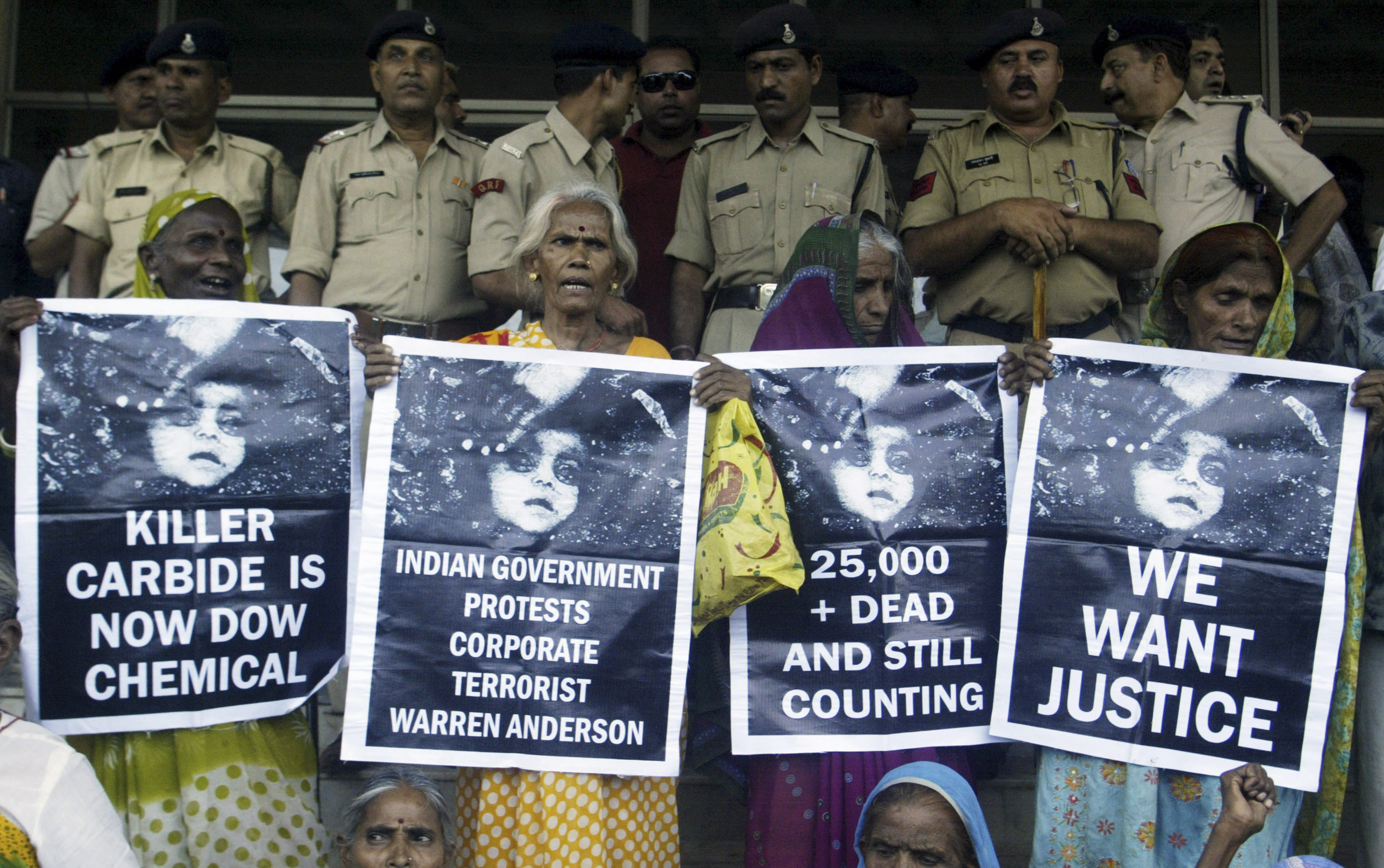 Victims of Bhopal gas tragedy hold posters during a demonstration outside a court in the central Indian city of Bhopal