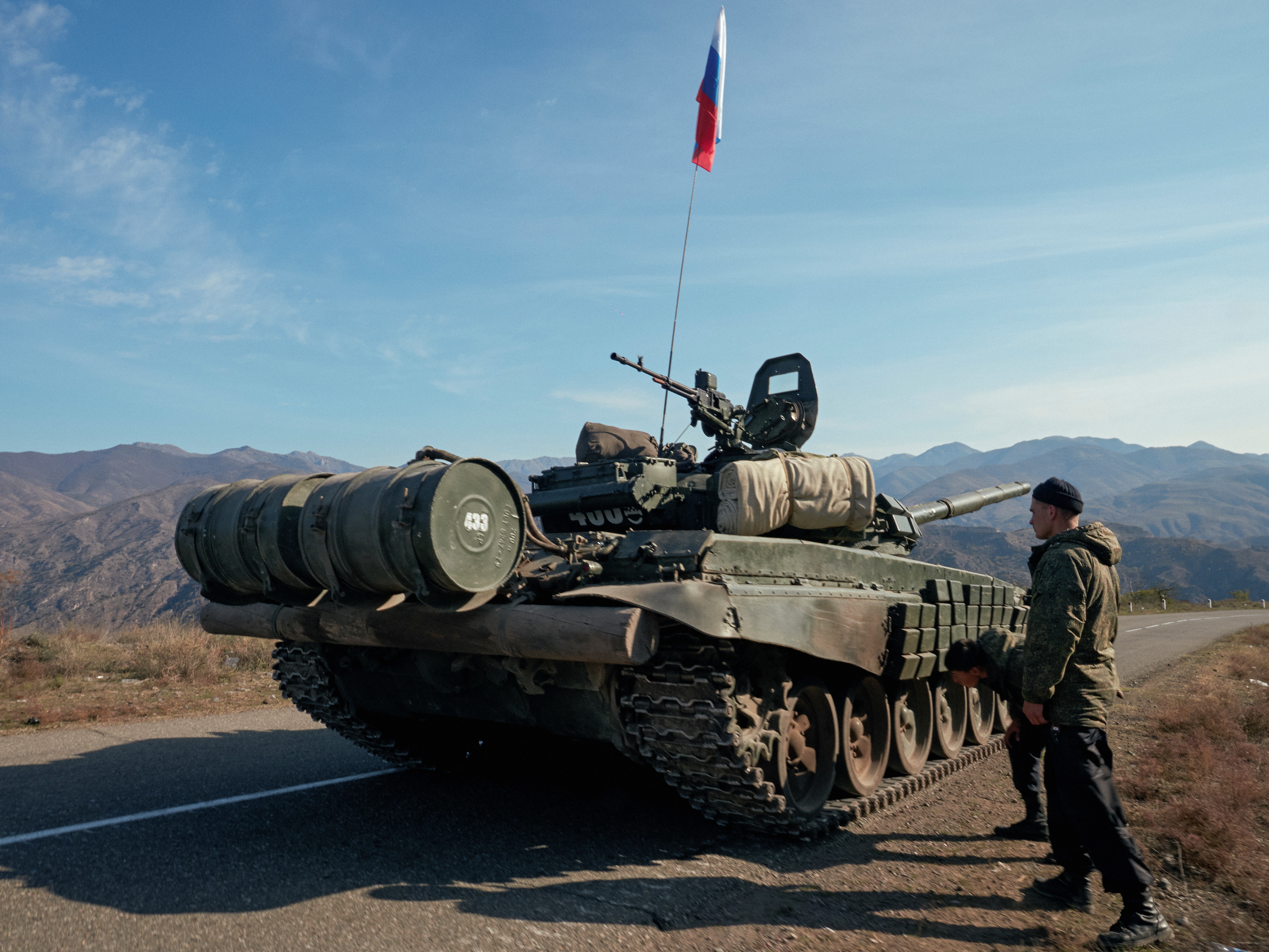 Service members of the Russian peacekeeping troops stand next to a tank near the border with Armenia in the region of Nagorno-Karabakh