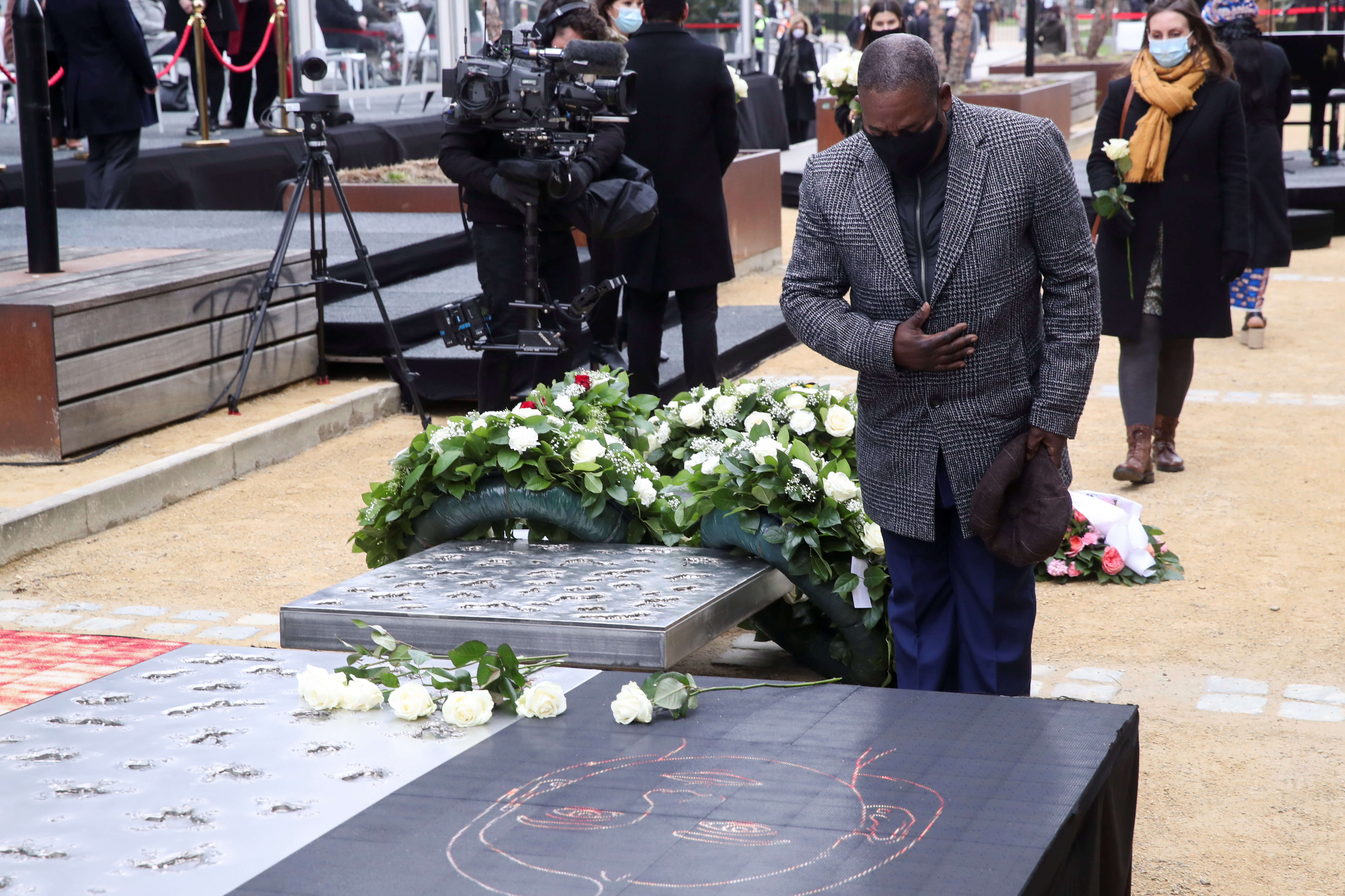 People pay their respects at the monument for the victims of the 2016 three suicide bombings on the fifth anniversary of the attacks, in central Brussels, Belgium March 22, 2021. REUTERS/Yves Herman/Pool