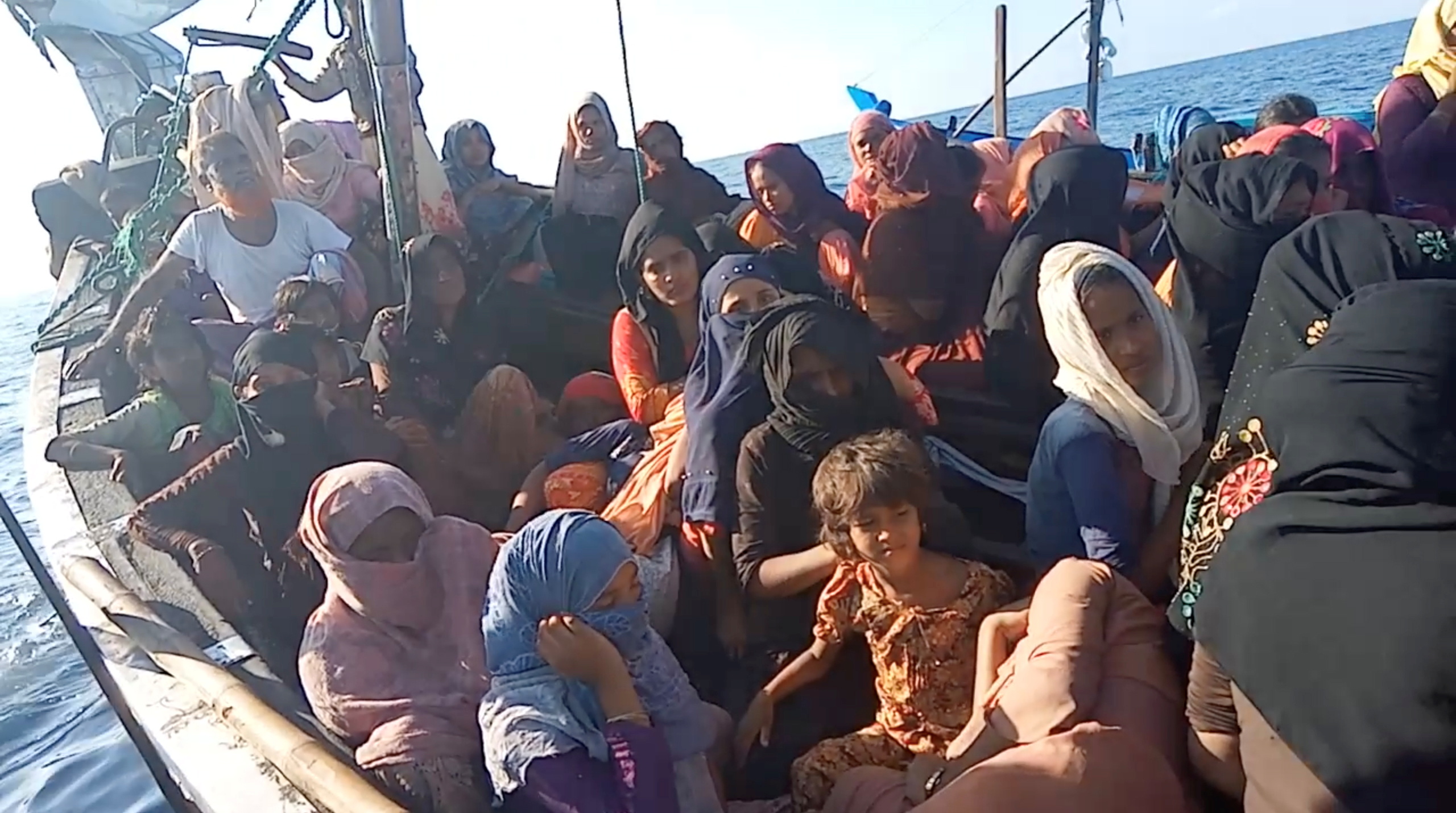 Rohingya refugees many of them women and some with childrem crowded onto a wooden boat stranded off Aceh in Indonesia. They look worried . The women are mostly veiled