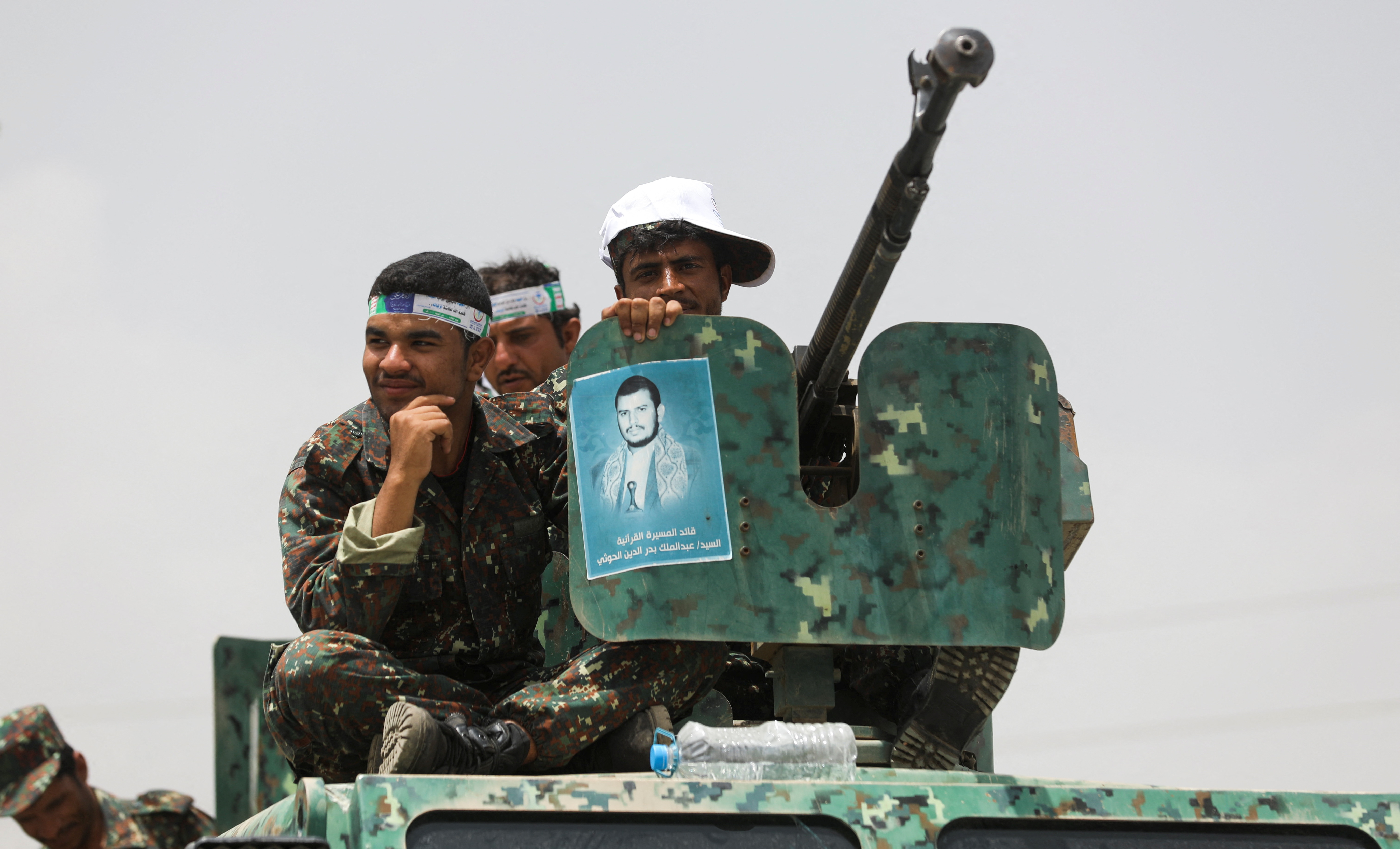 Houthi police troopers sit atop an armored personnel carrier securing a rally held to mark the Ghadeer day