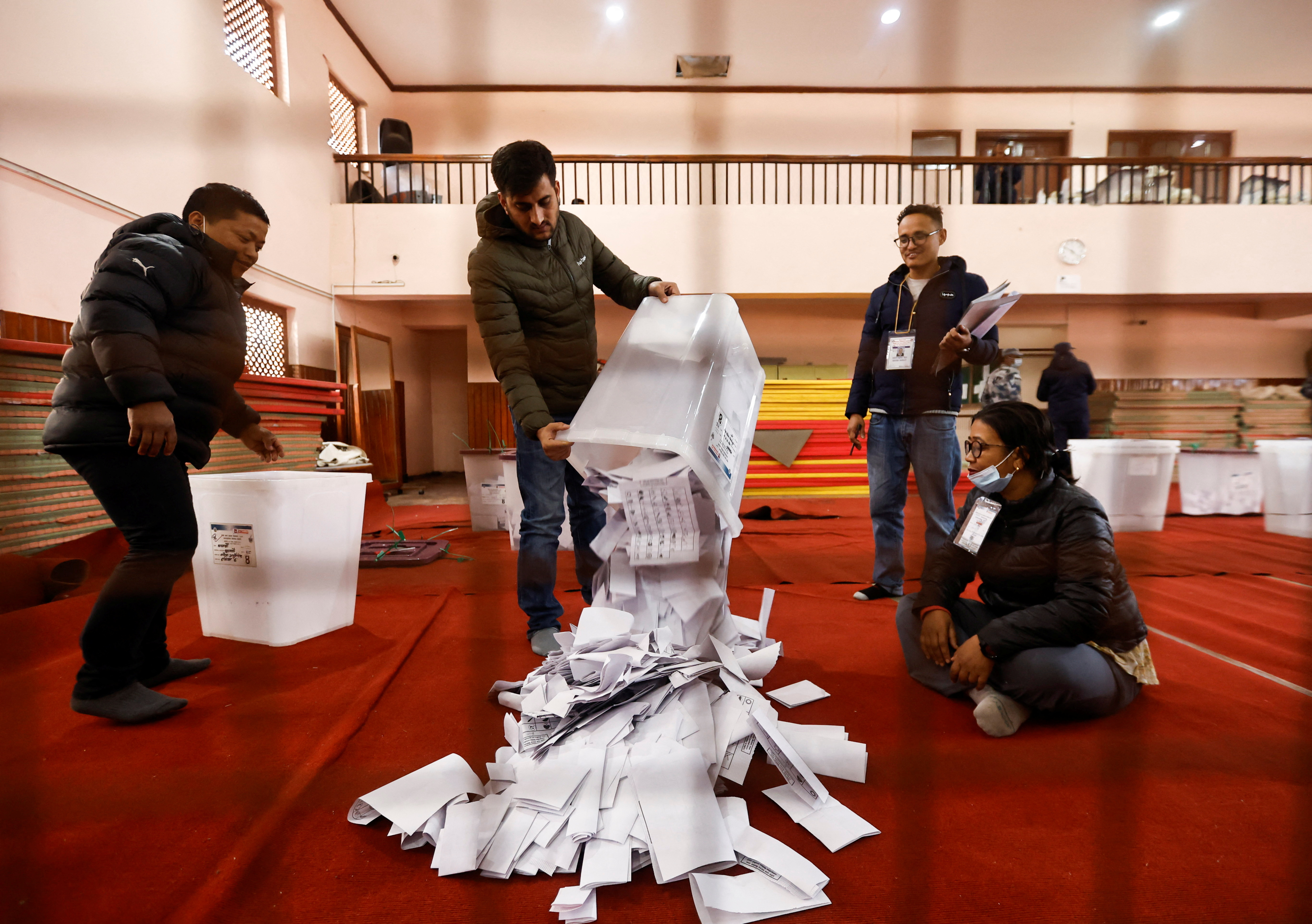 An official from Nepal's election commission pours the ballot papers from the box,