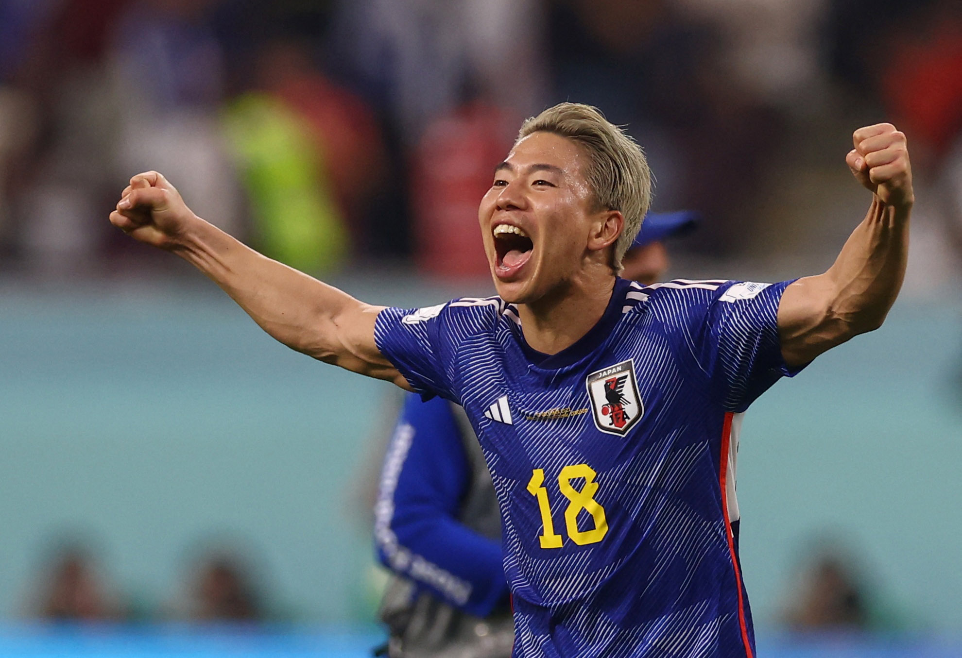 Japan's Takuma Asano with his mouth open, his face excited and his arms out