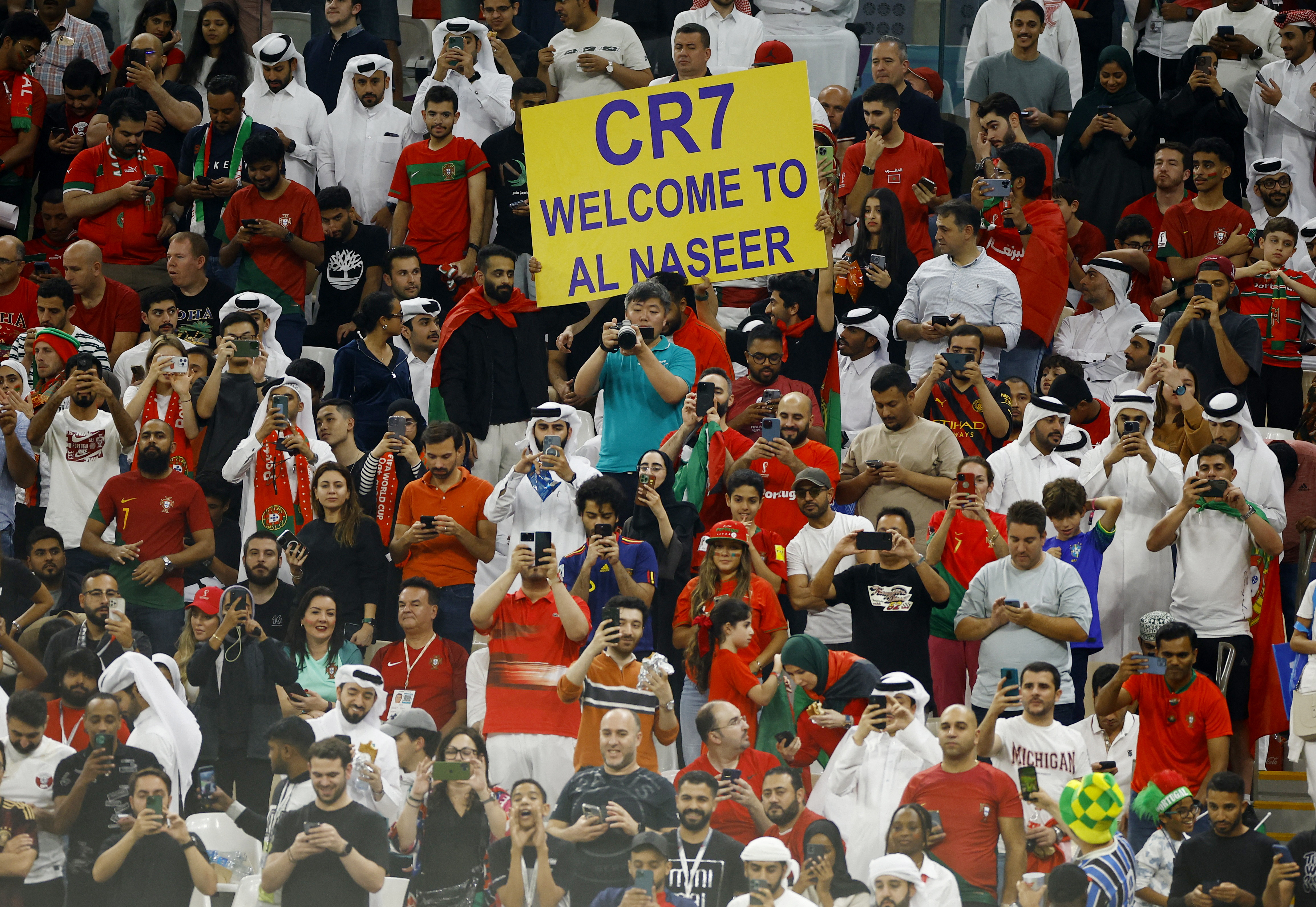 Soccer Football - FIFA World Cup Qatar 2022 - Round of 16 - Portugal v Switzerland - Lusail Stadium, Lusail, Qatar - December 6, 2022 Fans hold up a sign inside the stadium with a message welcoming Cristiano Ronaldo to Al-Nassr due to his prospective transfer REUTERS/John Sibley