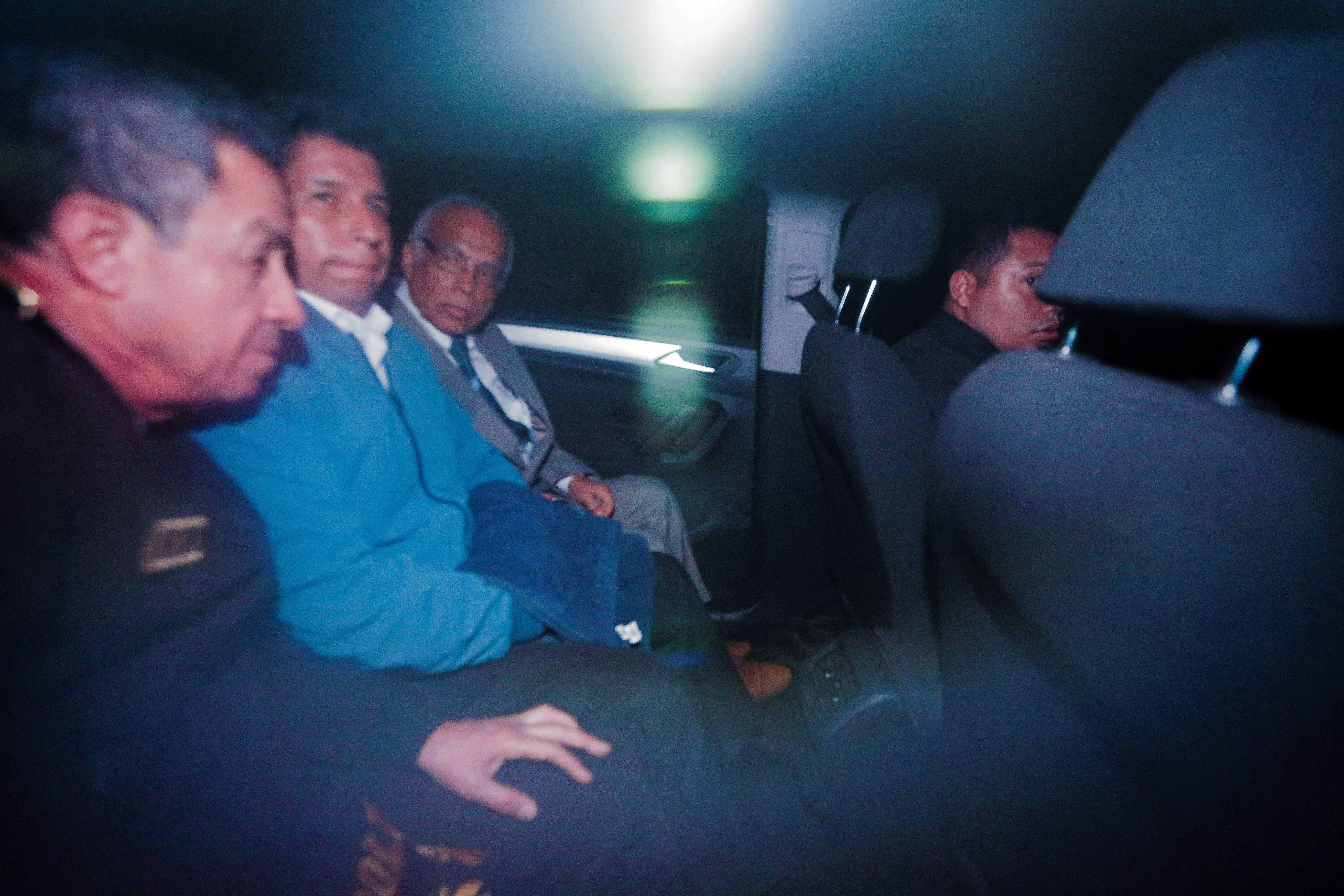 Pedro Castillo sitting in the back of car next to former Prime Minister Anibal Torres after leaving the police station in Lima
