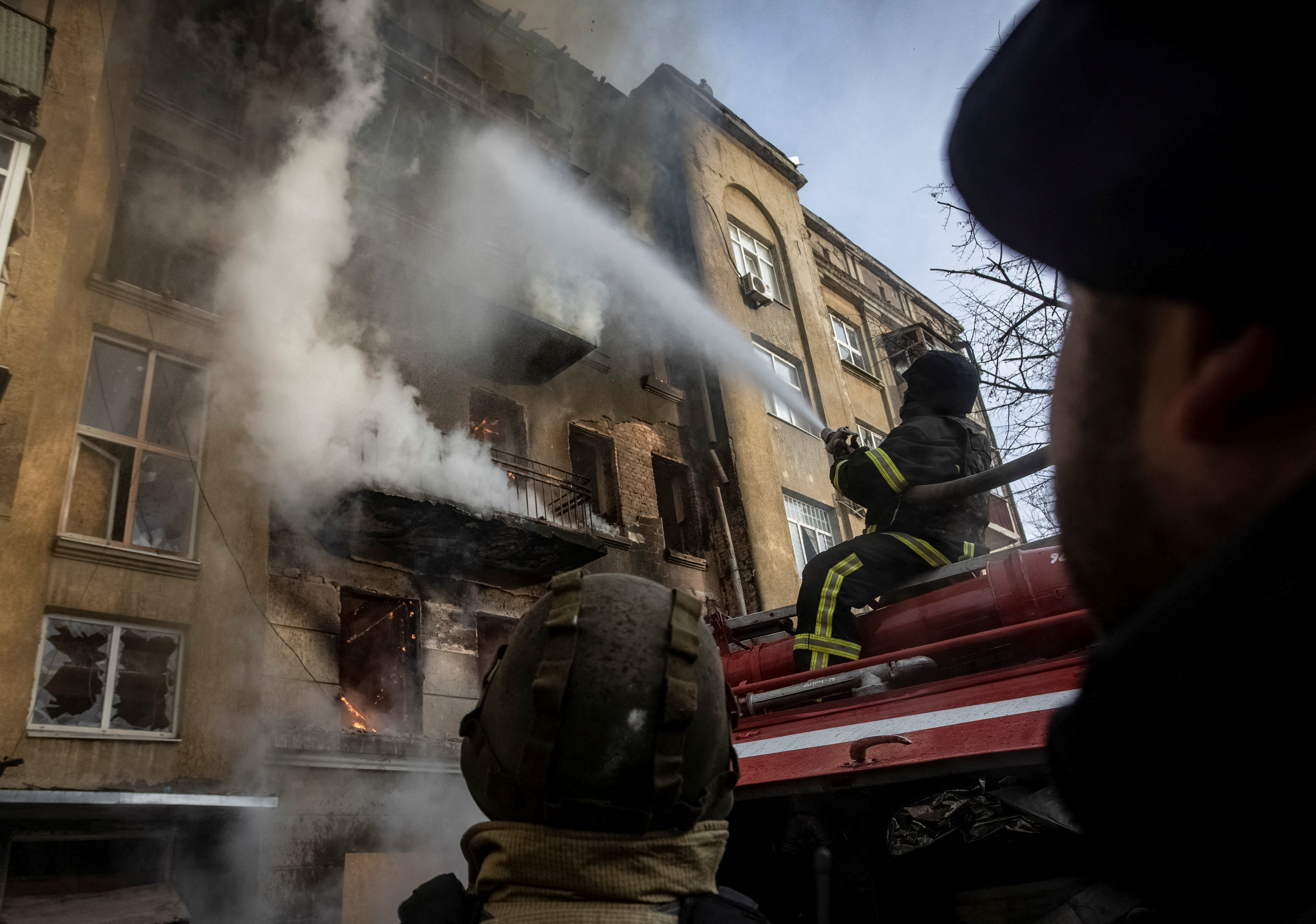 Firefighters work to put out a fire at a residential building hit by a Russian military strike in Bakhmut