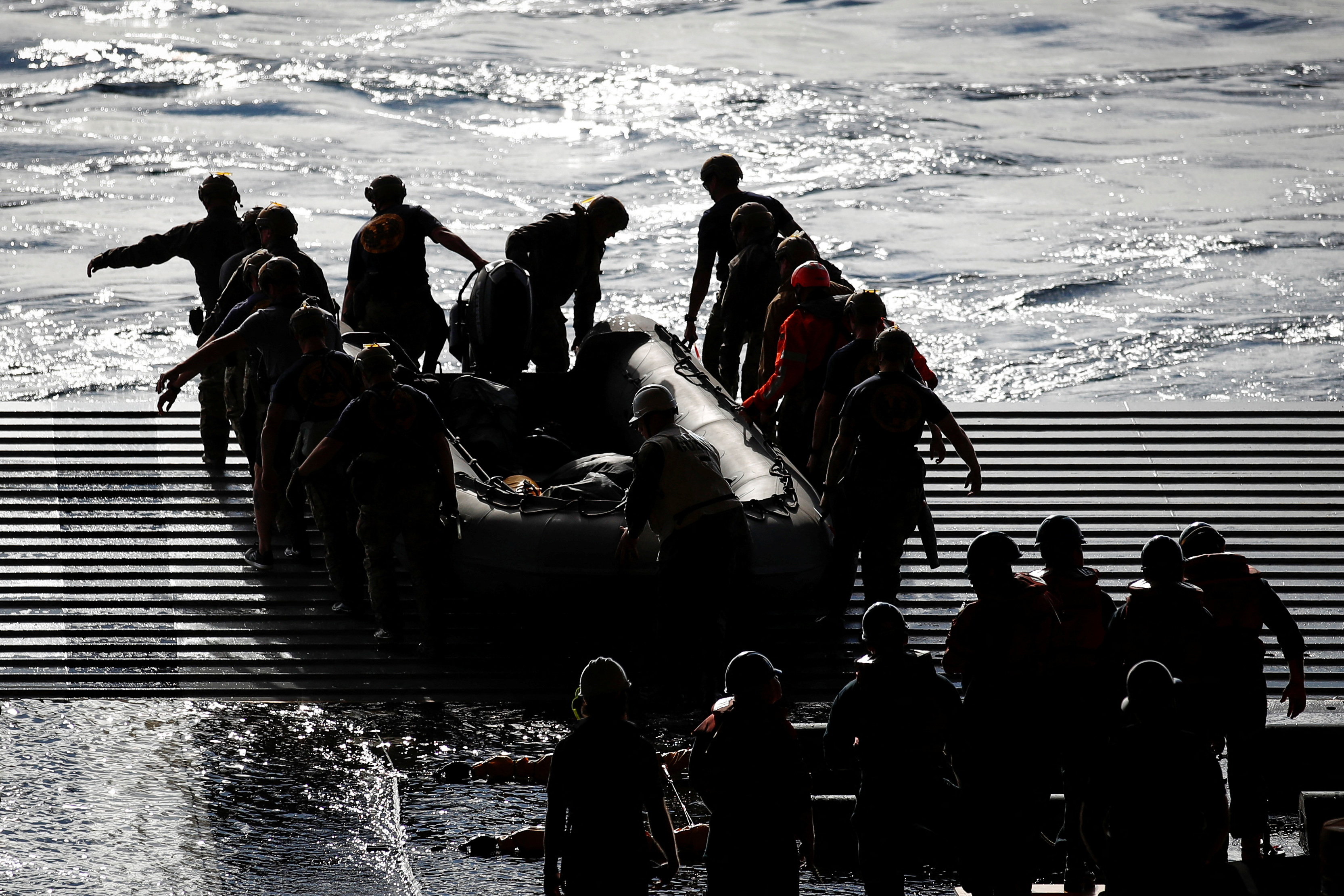 Navy sailors launch a small boat