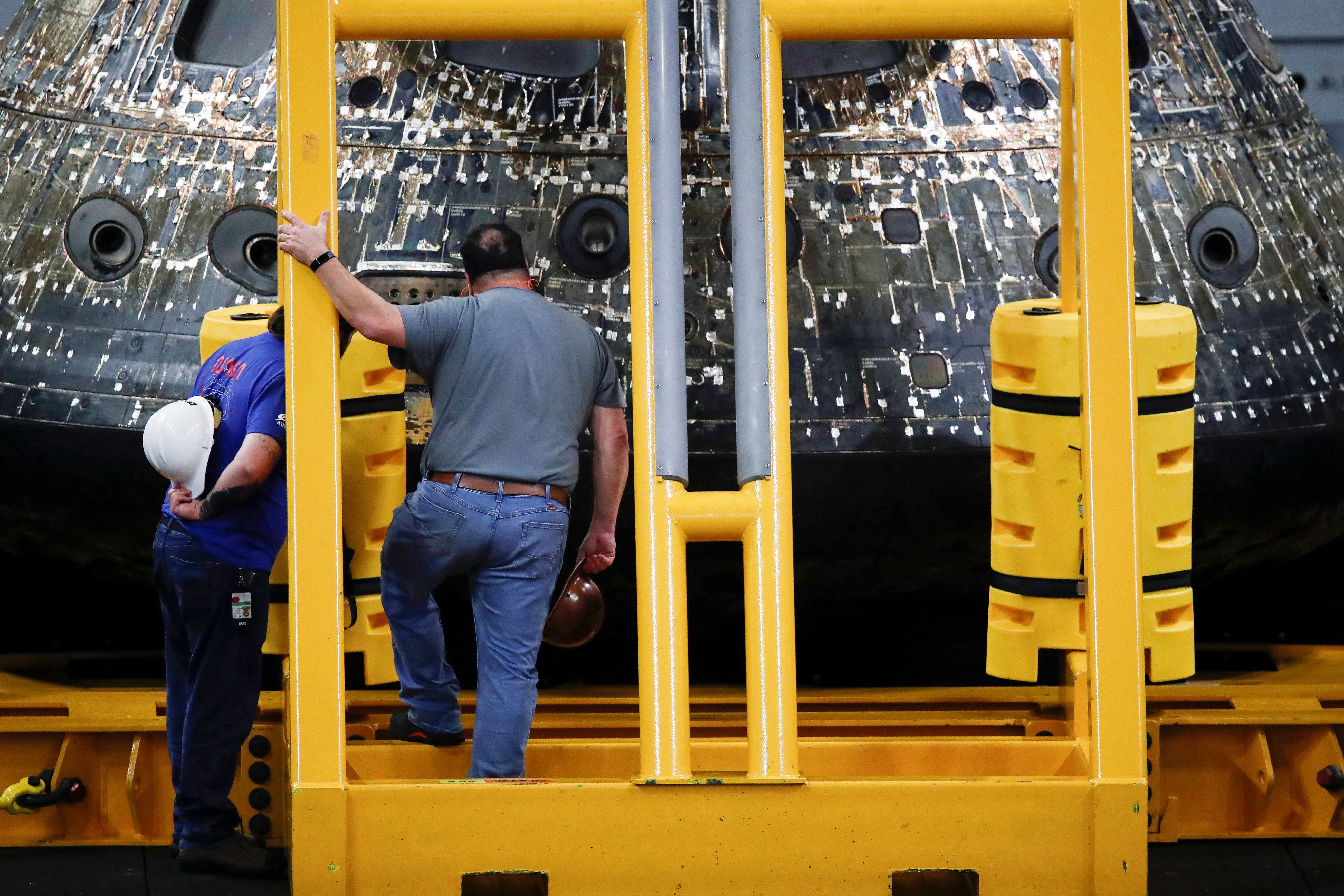 Orion team members inspect NASA’s Orion capsule