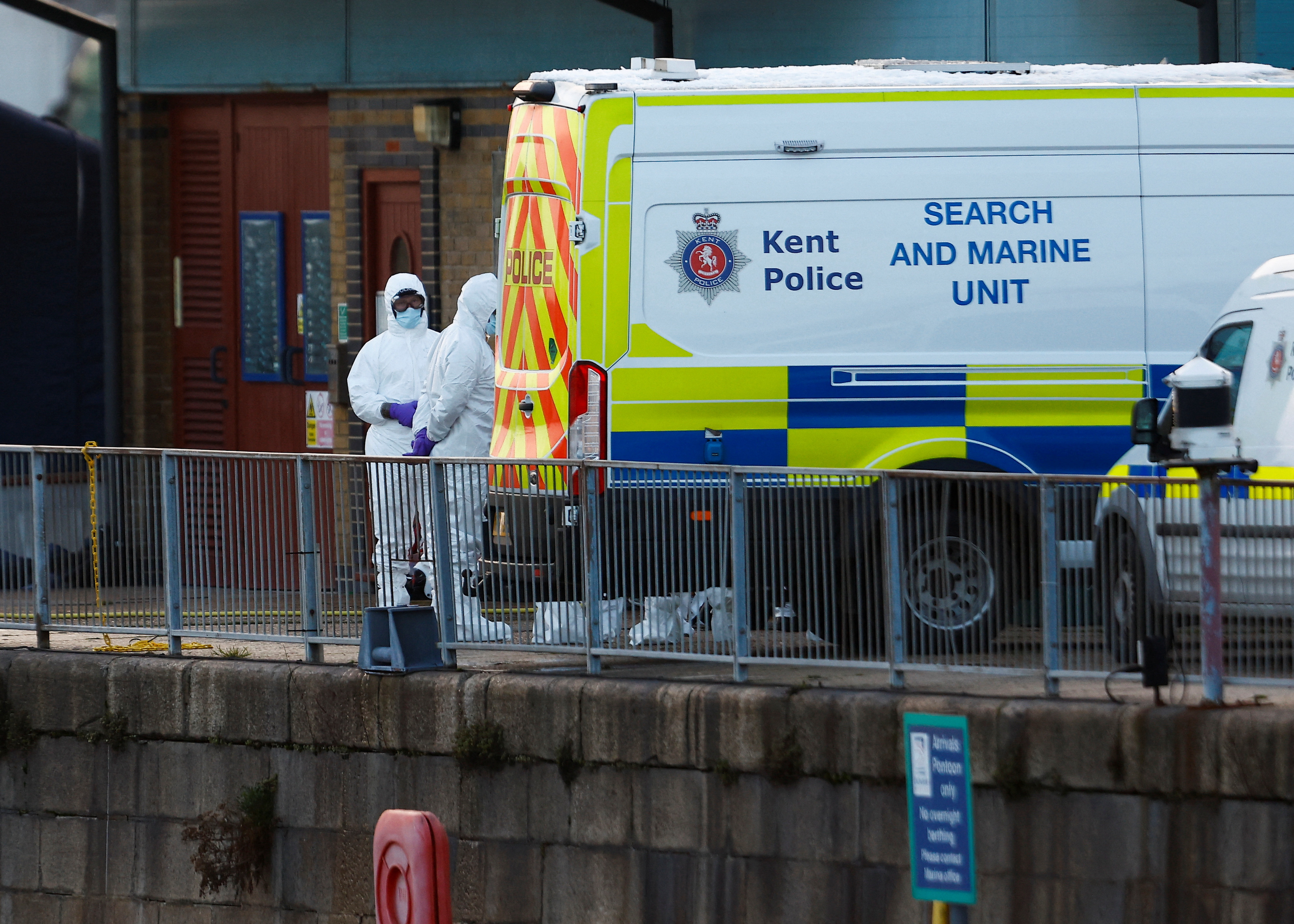 Police forensics officers wearing protective gear gather next to a Search and Marine Unit vehicle, amid a rescue operation at the Port of Dover in Dover, the UK.