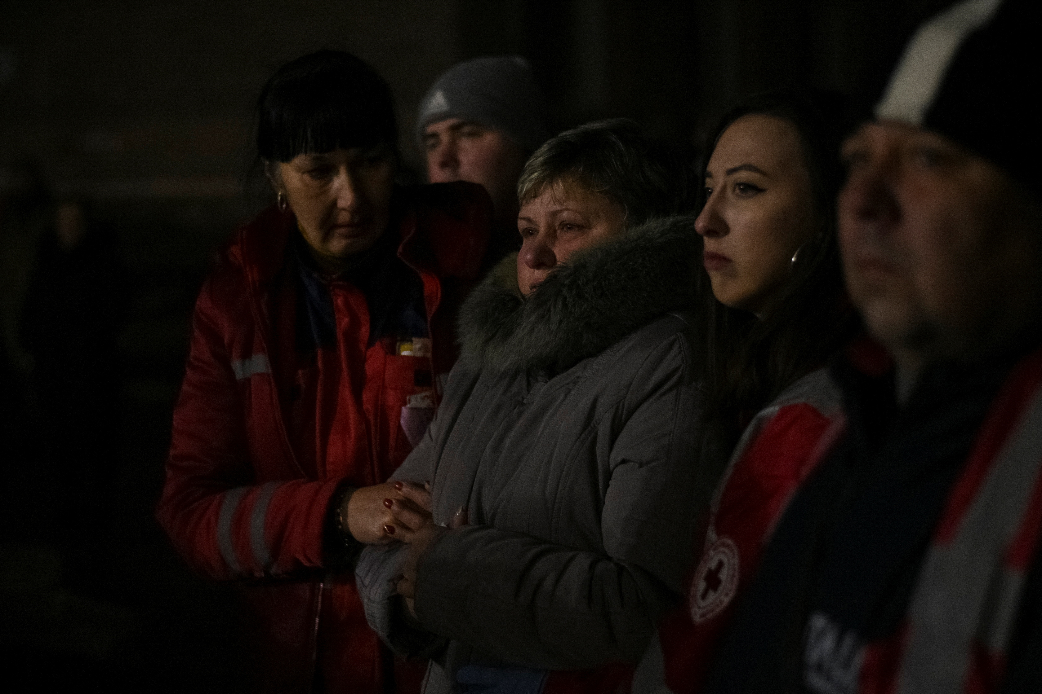 A local woman looks at her residential building damaged by a Russian missile.