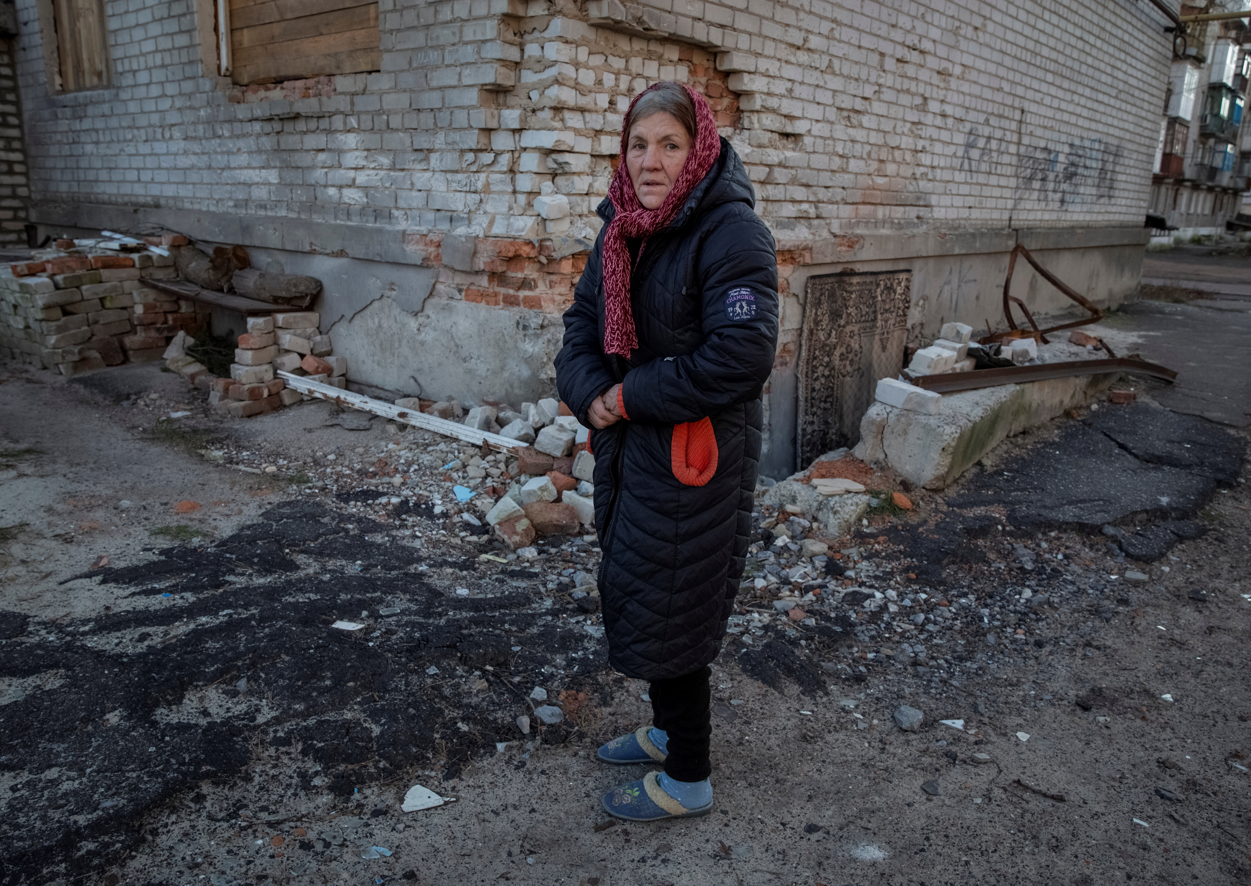 A local resident stands near her residential house destroyed by a Russian military strike, as Russia's attack on Ukraine continues, in Lyman, Ukraine December 19, 2022. REUTERS/Oleksandr Ratushniak
