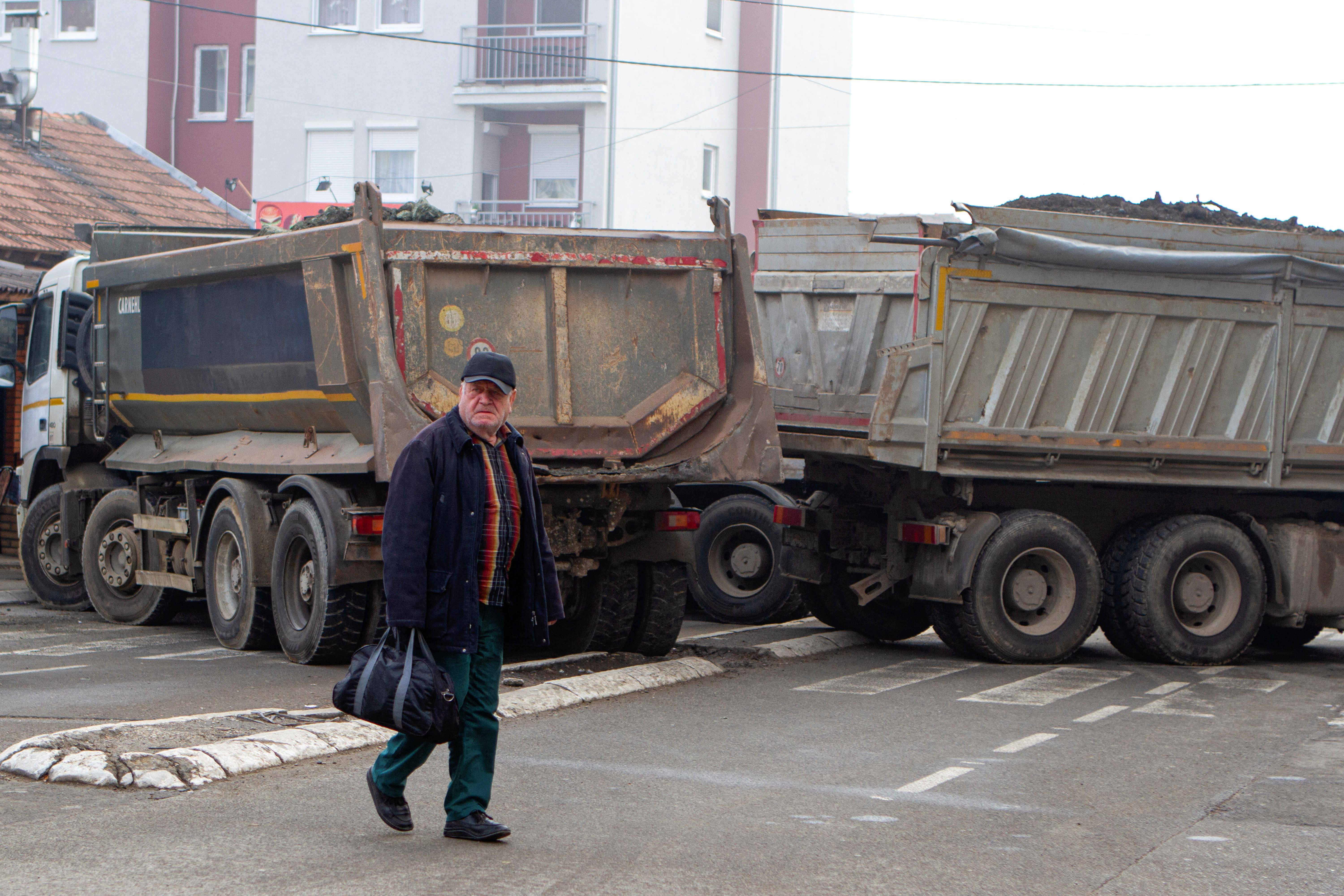 A man crosses a street near a roadblock in the northern part of the ethnically-divided town of Mitrovica, Kosovo, December 27, 2022