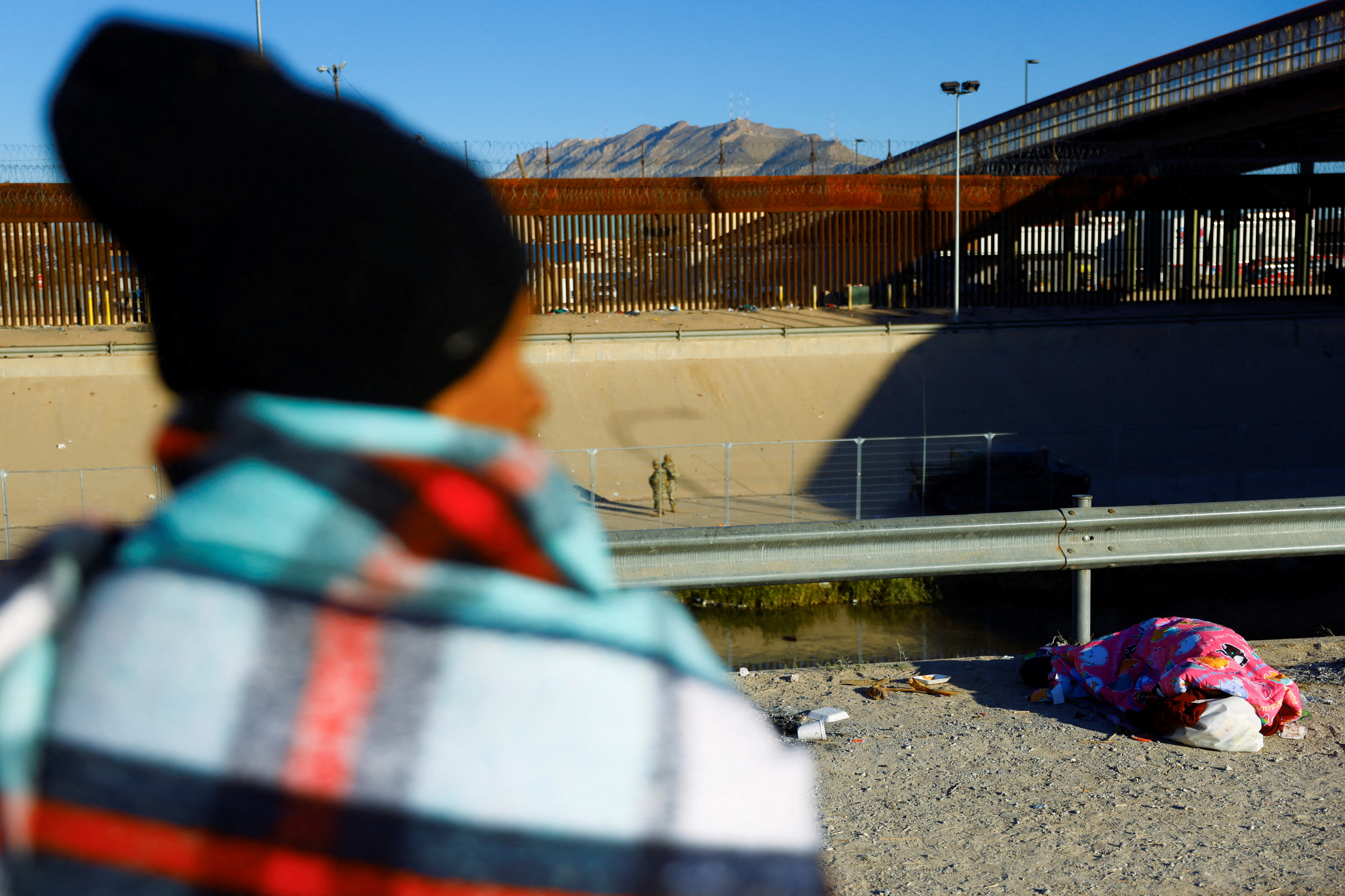 Migrants and refugees rest near the Rio Bravo River on the US-Mexico border