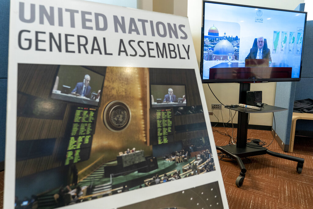 Palestinian President Mahmoud Abbas is seen on a video screen outside the General Assembly hall as he addresses the the 76th Session of the United Nations General Assembly remotely, Friday, Sept. 24, 2021 at U.N. headquarters. (AP Photo/Mary Altaffer)