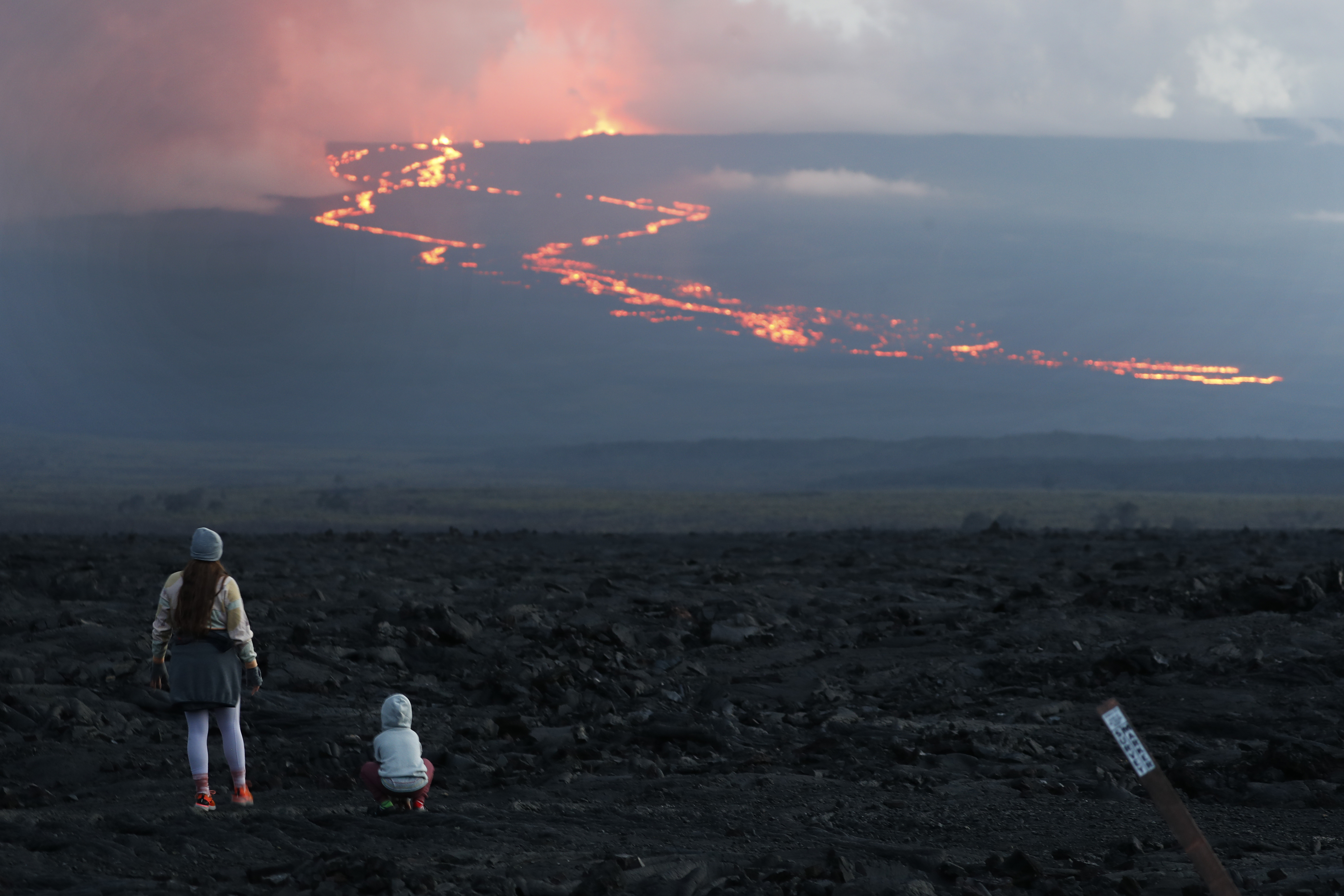 Spectators watch the lava flow down the mountain