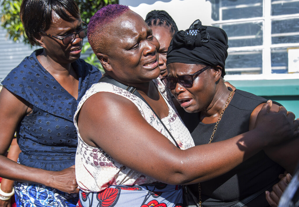 Florence Nyirenda, mother of Lemekhani Nyireda, is comforted by family members at the Kenneth Kaunda International Airport in Lusaka, Zambia, Sunday, Dec. 11 2022. The body of a 23-year-old Zambian student who died while fighting for the Russian army in the war in Ukraine has been returned home. The body of Lemekani Nyirenda who was studying nuclear engineering in Russia before joining the military arrived at Kenneth Kaunda International Airport in Lusaka on Sunday. (AP Photo/Salim Dawood)
