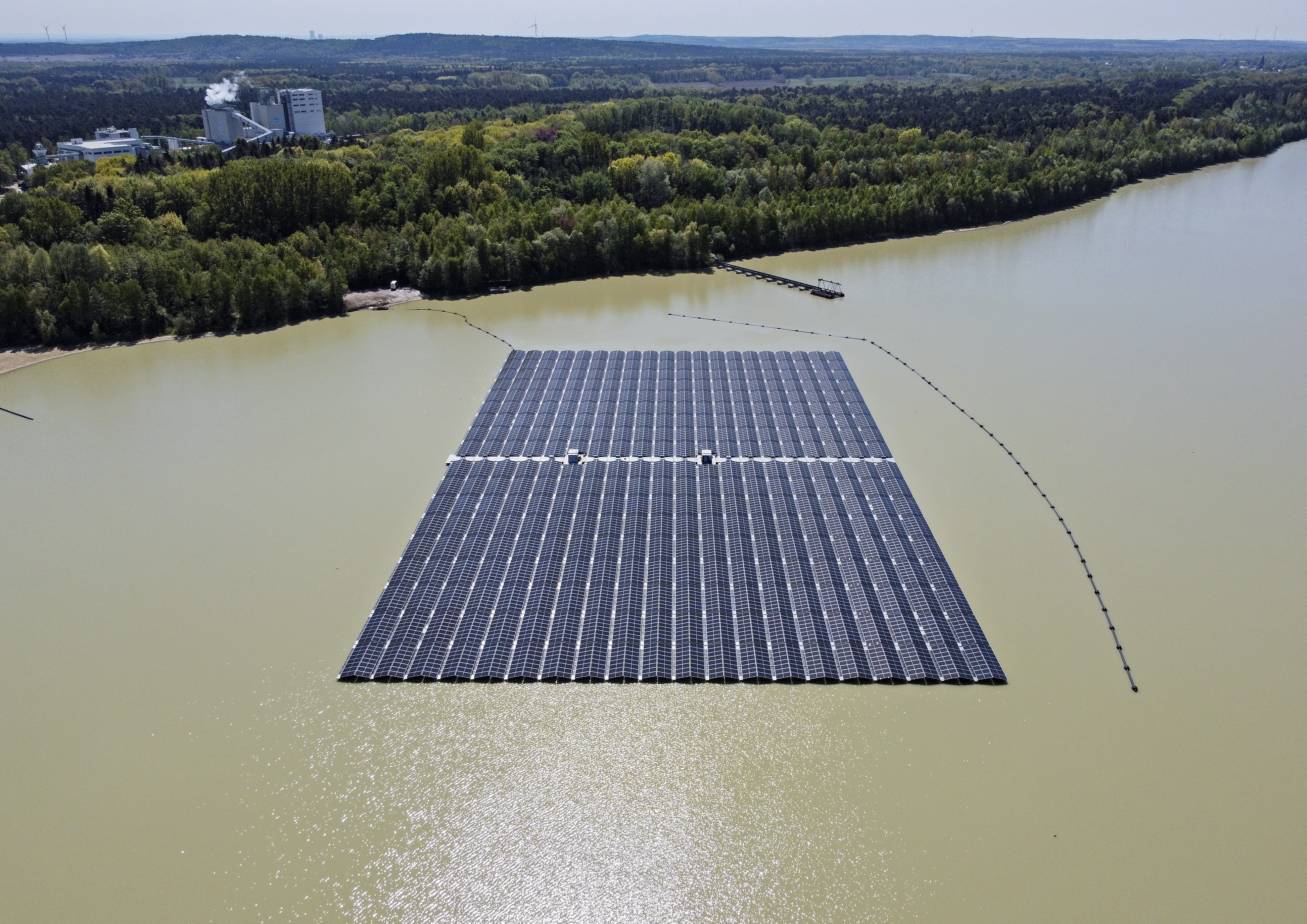 Solar panels on Germany's biggest floating photovoltaic plant produce energy under a blue sky