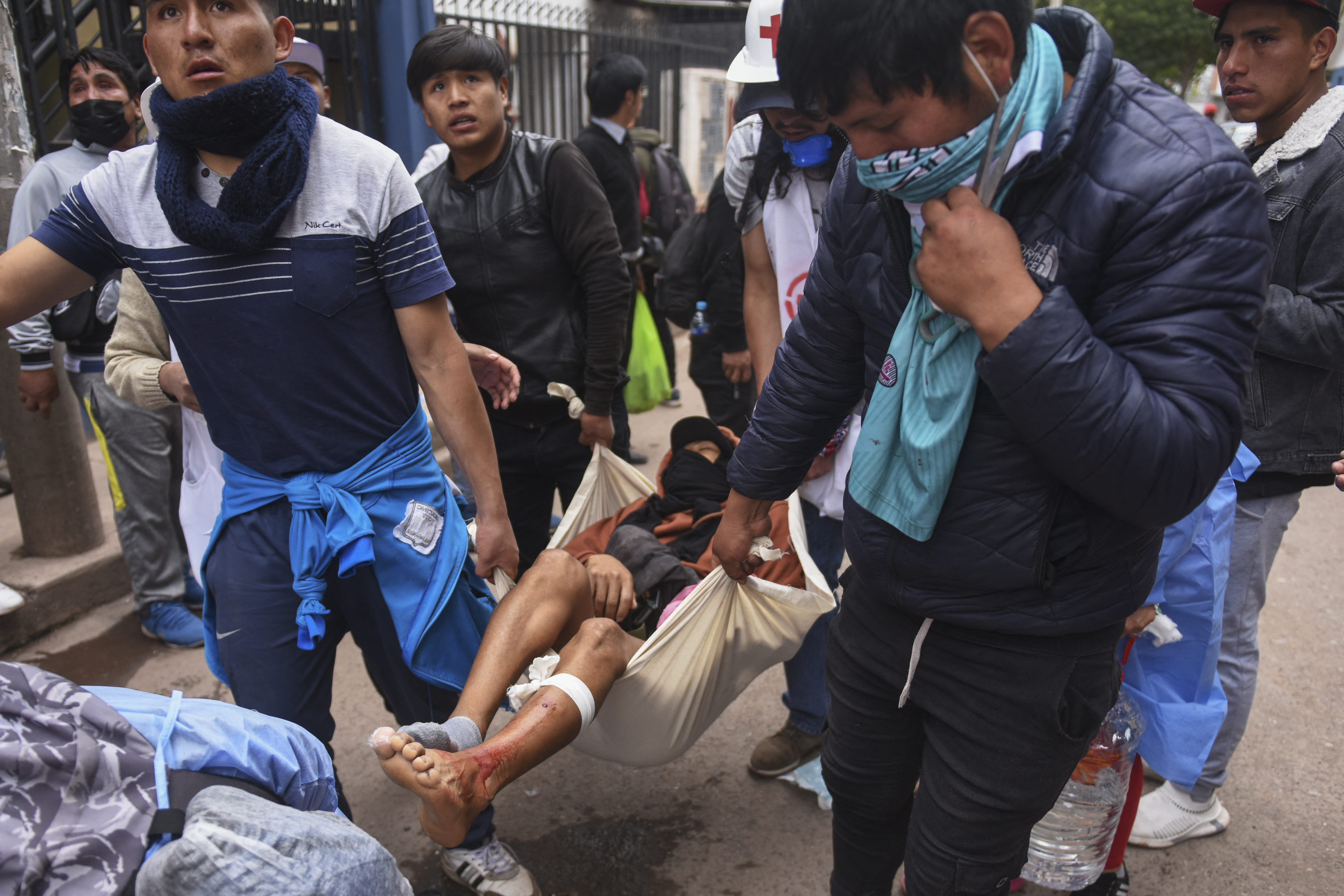 A wounded protester is taken away during a demonstration in Cusco, Peru, on January 11, 2023. - Peru's prosecutor's office on the eve opened an inquiry against President Dina Boluarte and others for their role in the repression of anti-government protests that have seen at least 40 killed since December. (Photo by Ivan Flores / AFP)