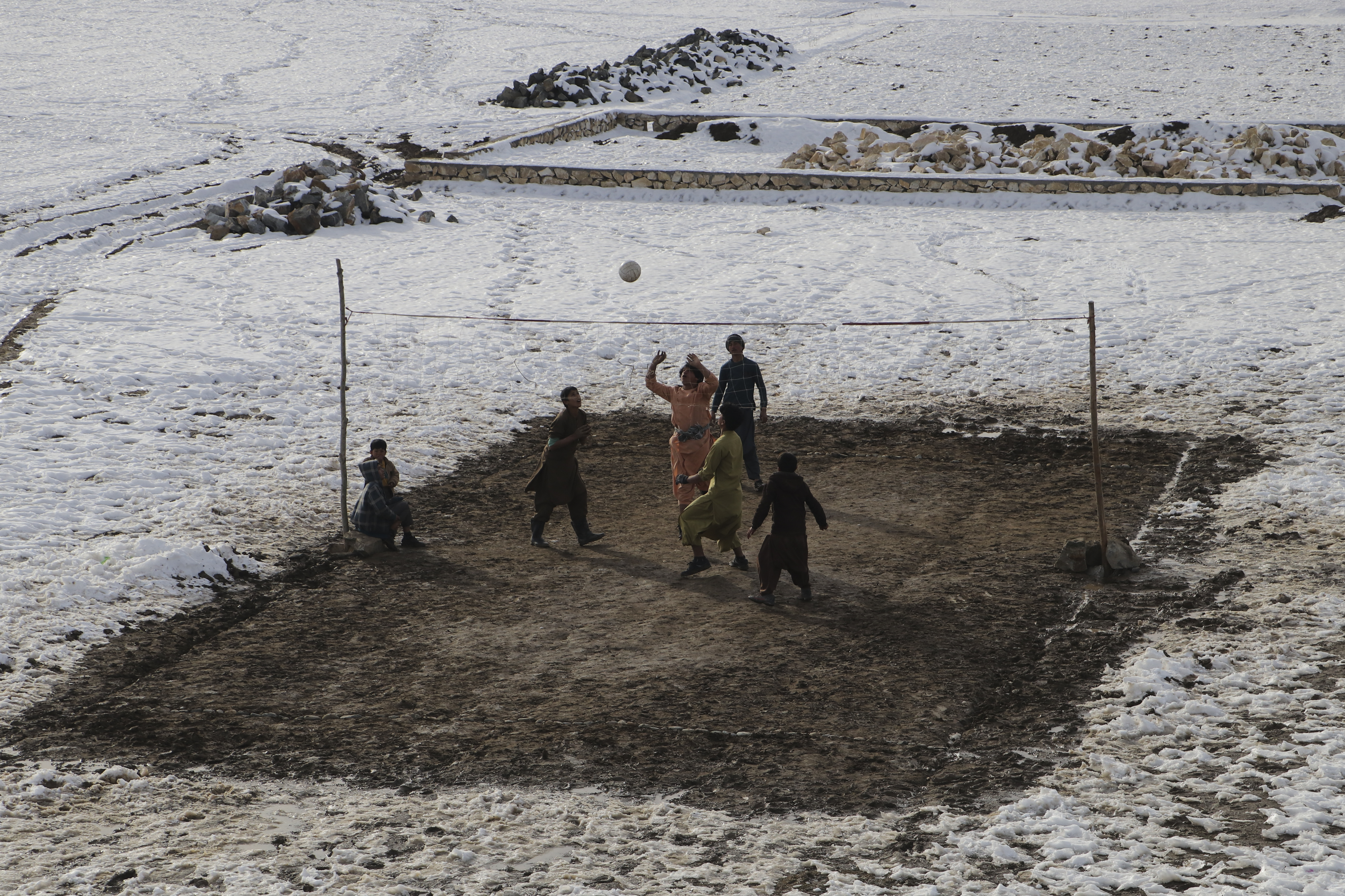 People play volleyball during a cold winter day in Yaftal Sufla district of Badakhshan Province on January 18, 2023. - At least 70 people have died in a wave of freezing temperatures sweeping Afghanistan, officials said on Janaury 18, as extreme weather compounds a humanitarian crisis in the poverty-stricken nation. (Photo by OMER ABRAR / AFP)