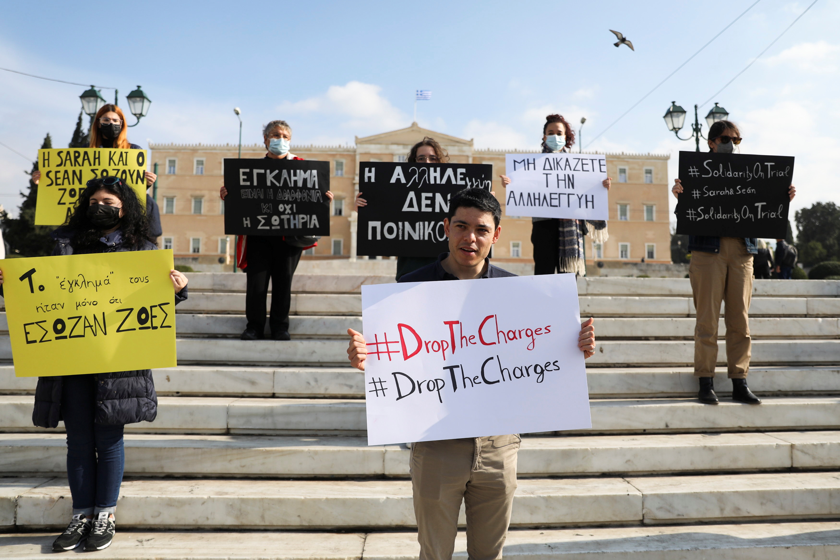 Sean Binder holds a placard during a demonstration by Amnesty International activists in solidarity with Sean Binder and Sarah Mardini