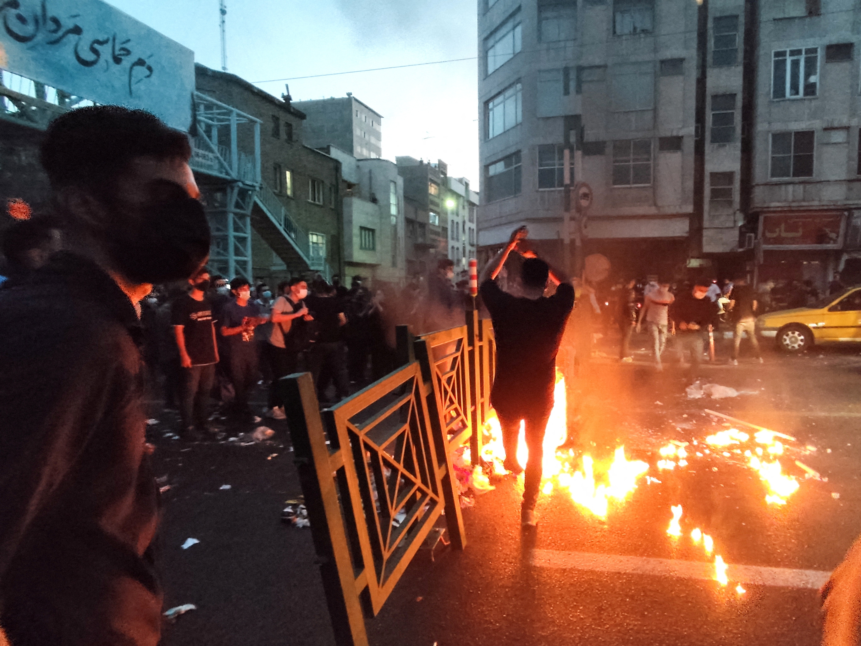 People light a fire during a protest over the death of Mahsa Amini