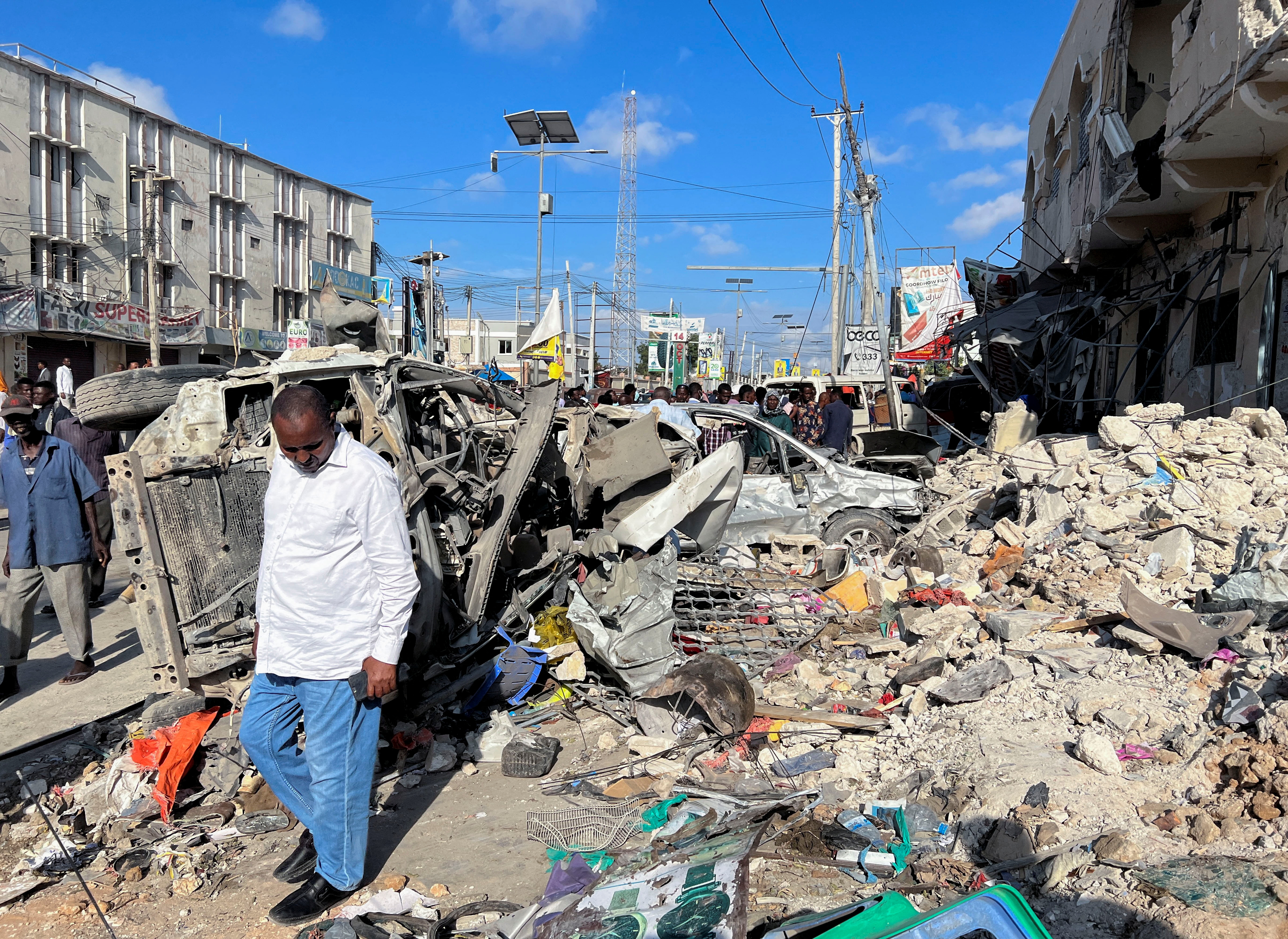 A man walks past wreckage from a bombing in Moghadishu