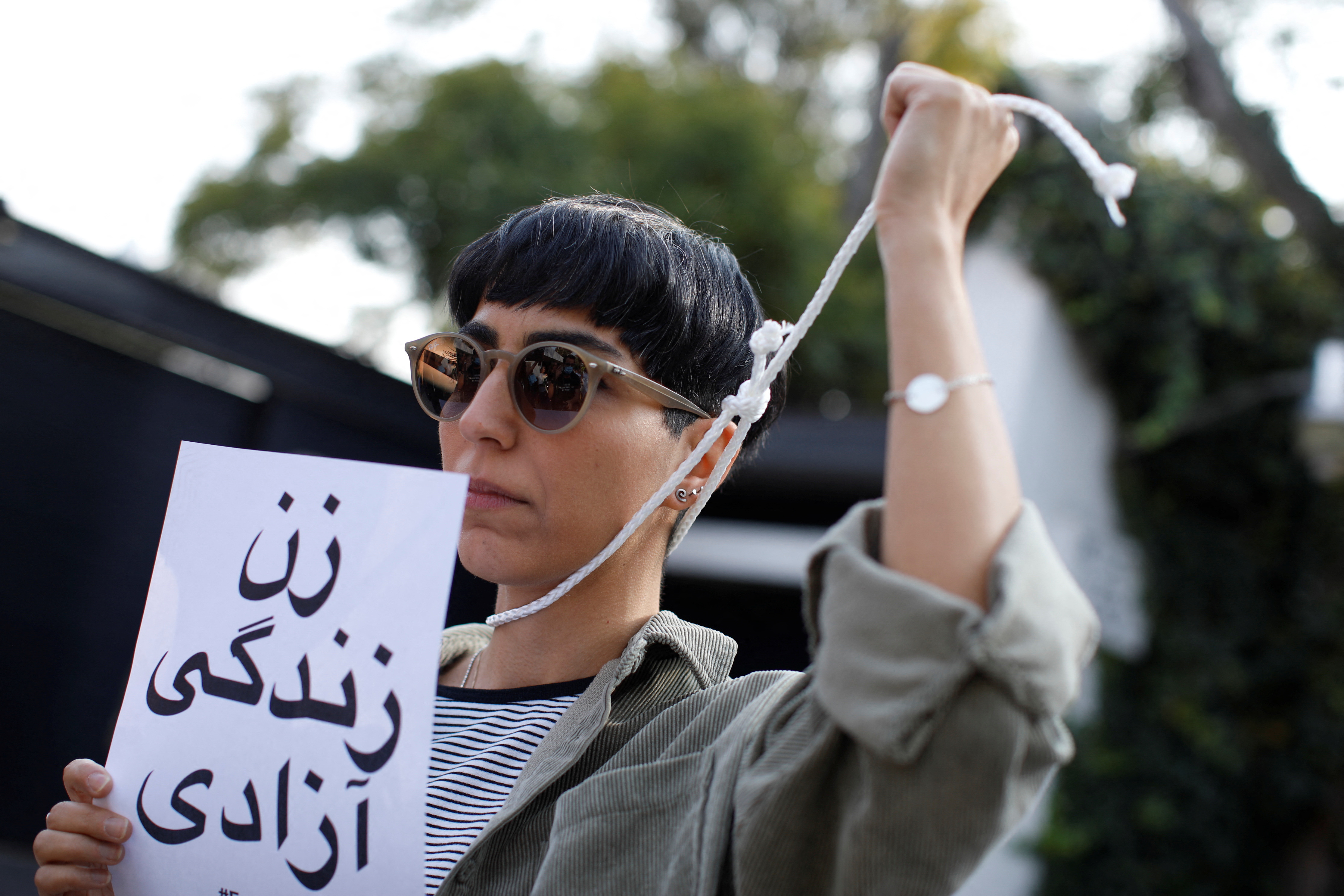 A woman holds up a rope during a protest against Iran's ruling theocracy following the death of young Kurdish Iranian woman Mahsa Amini