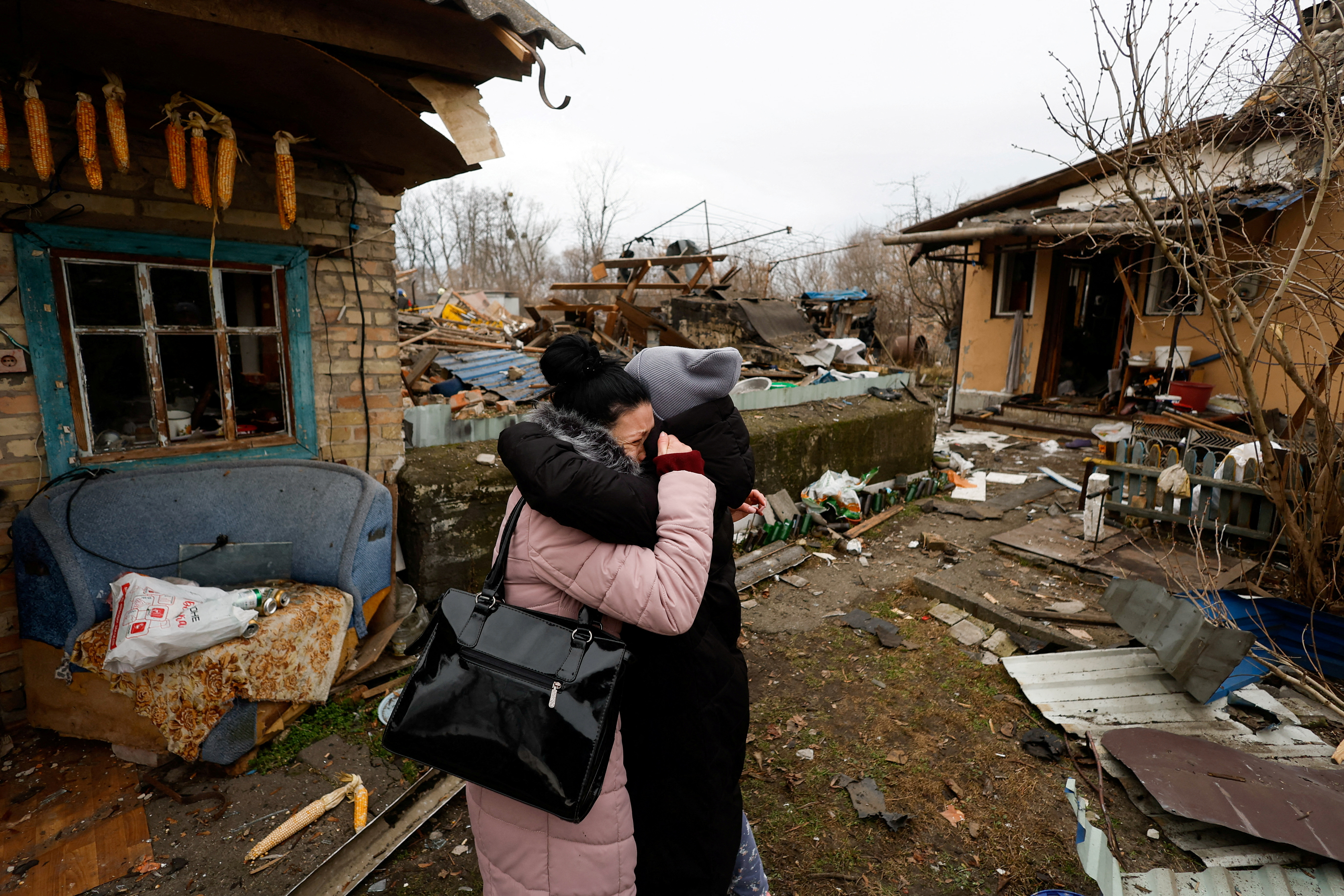 A Kyiv resident embraces a friend as she reacts next to her mother's house damaged during a Russian missile raid in Kyiv, Ukraine.