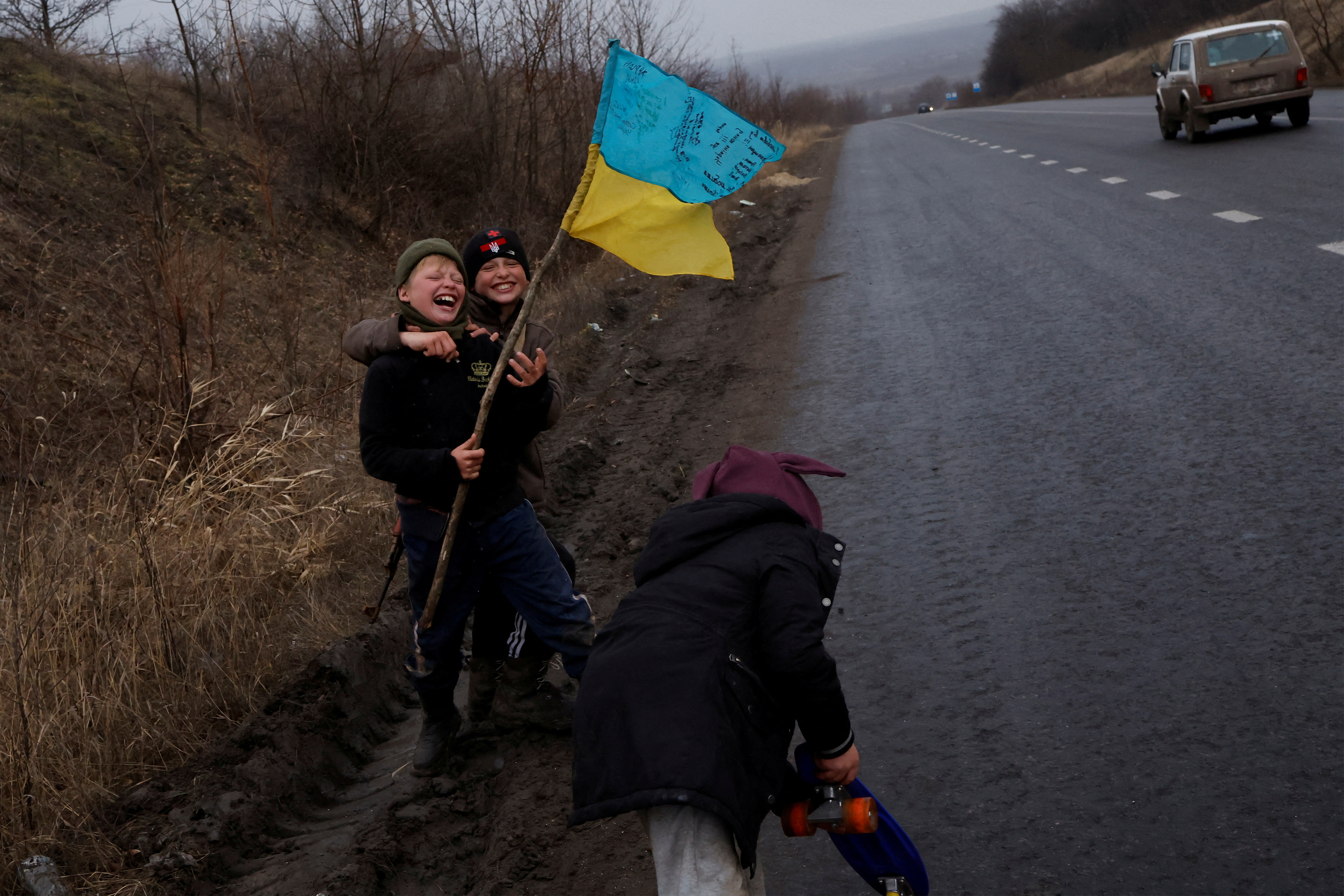 Children play along the side of the road in Bakhmut, Ukraine