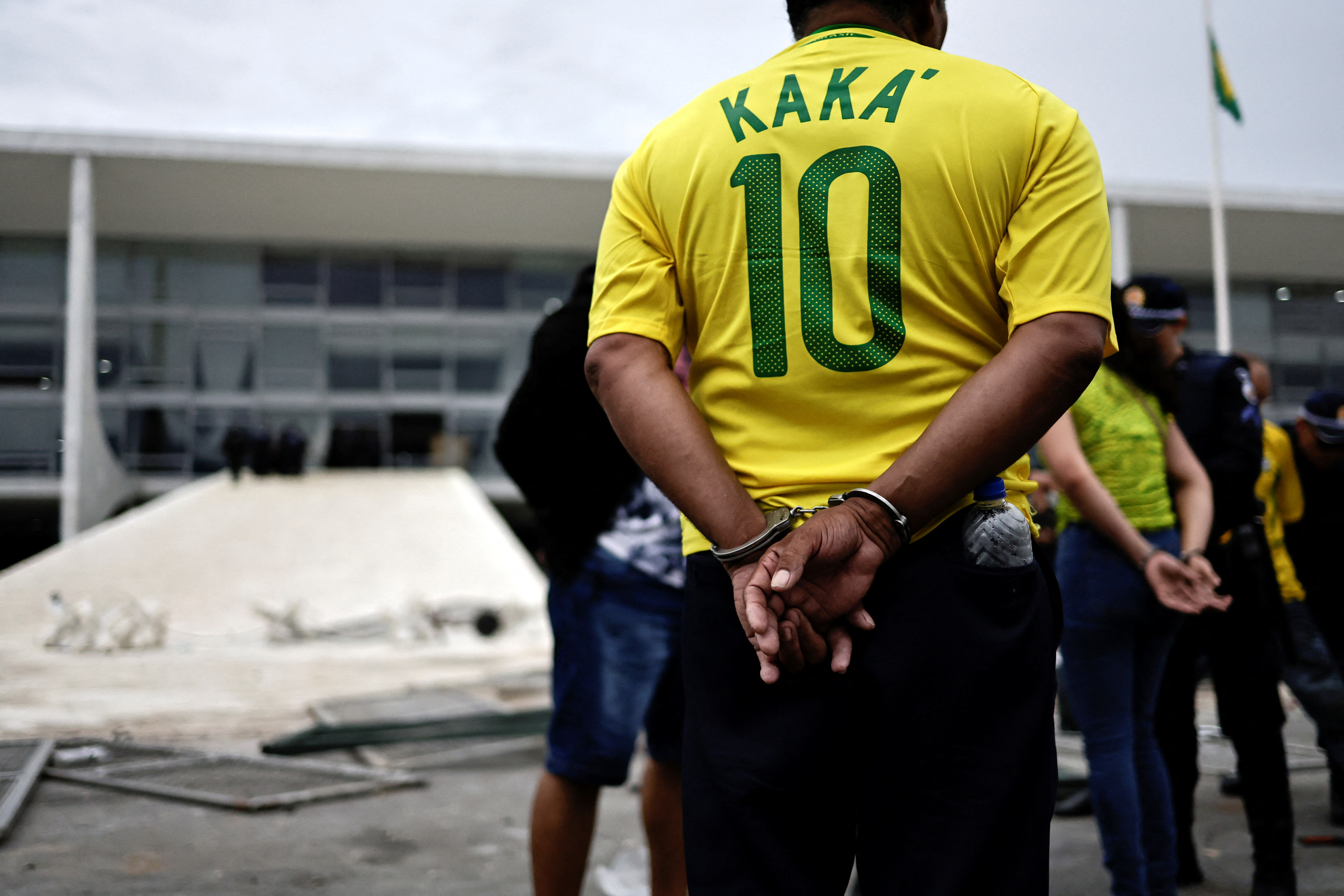 A man stands in handcuffs after the storming of Brazilian government offices in Brasilia