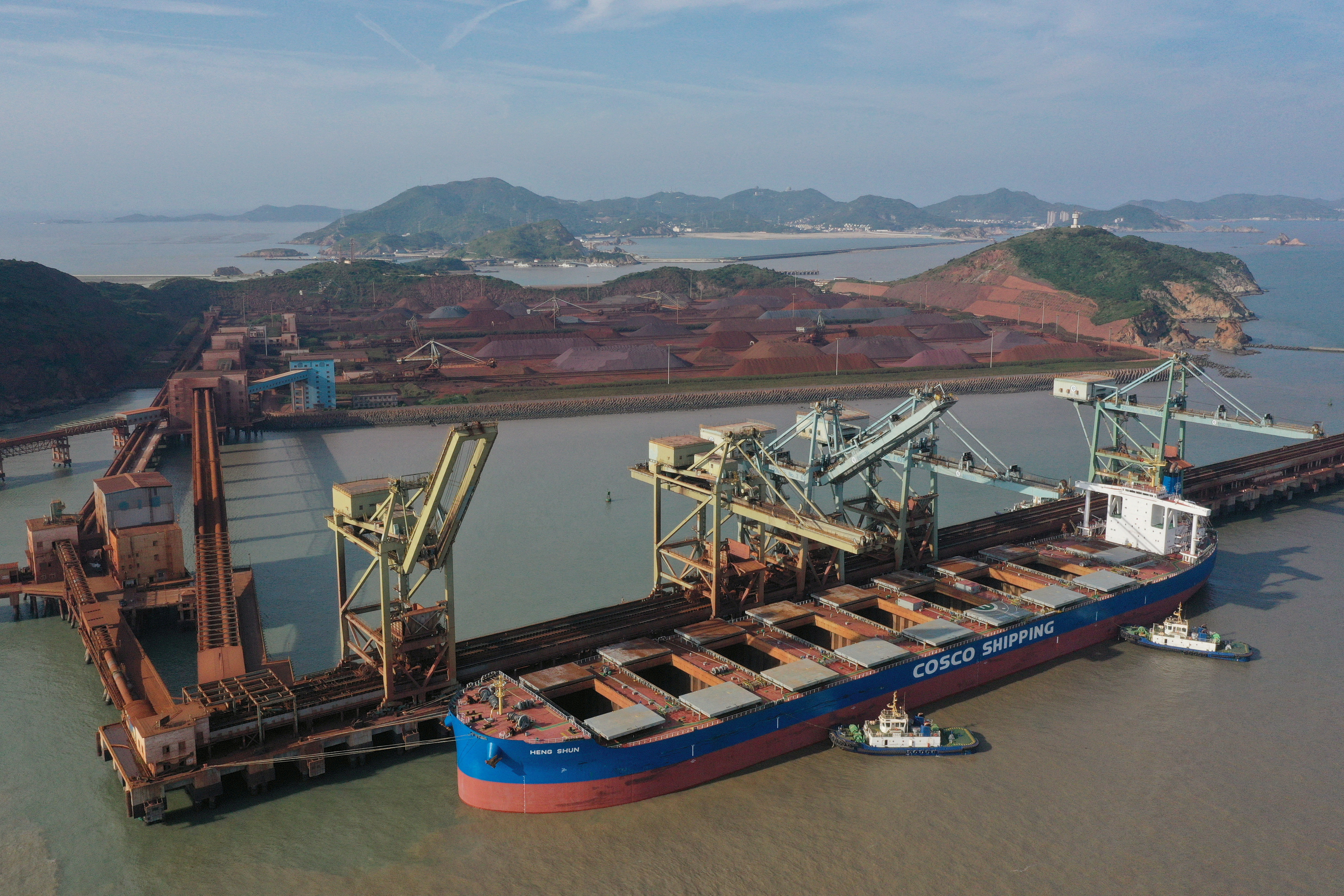 A China Ocean Shipping Company (COSCO) vessel is seen docked after unloading the imported iron ore at a port in Zhoushan, Zhejiang province, China [File: Stringer/Reuters]