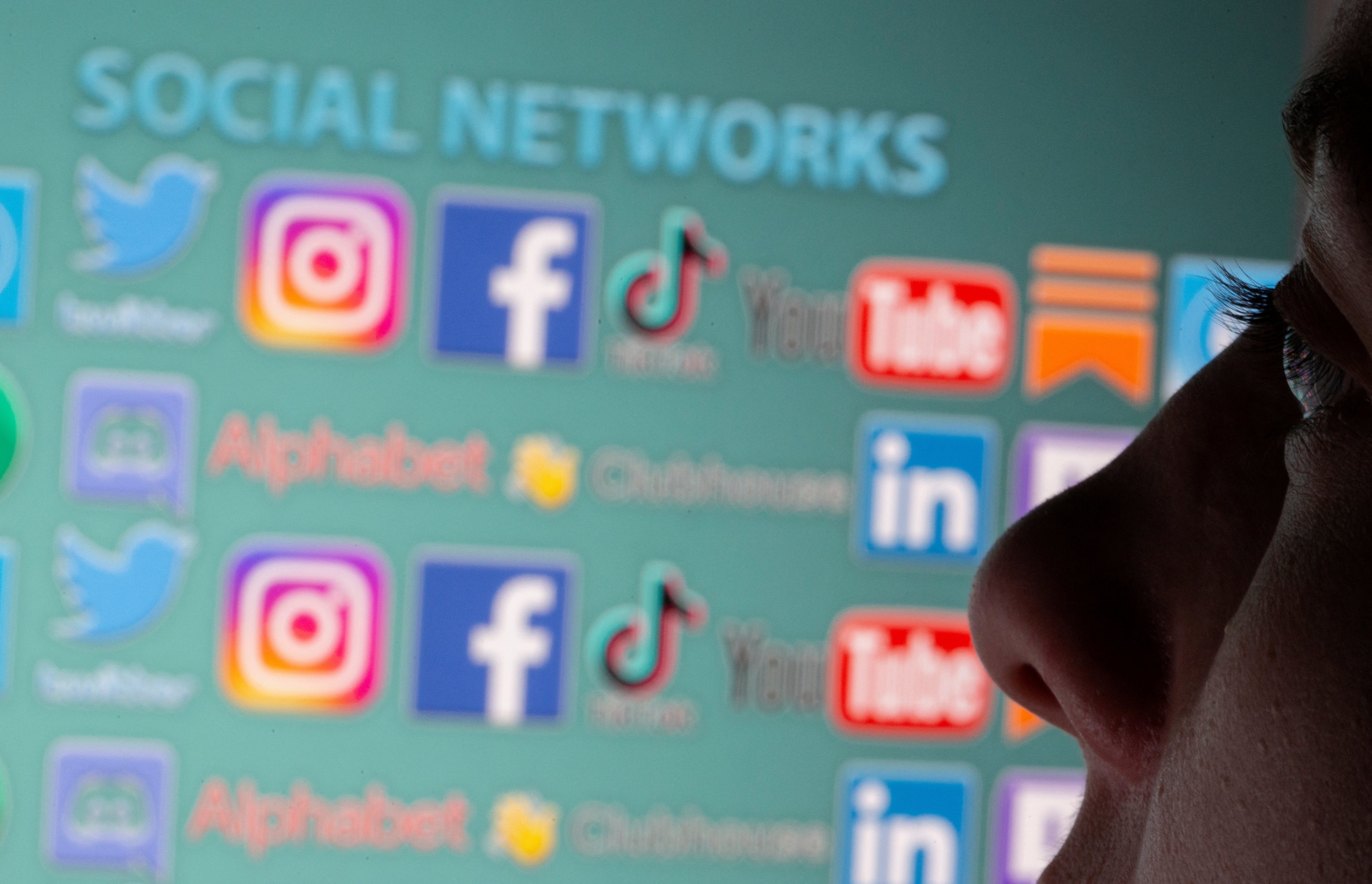 FILE PHOTO: Woman is seen in front of displayed social media logos in this illustration taken, May 25, 2021. Picture taken May 25, 2021. REUTERS/Dado Ruvic/Illustration/File Photo