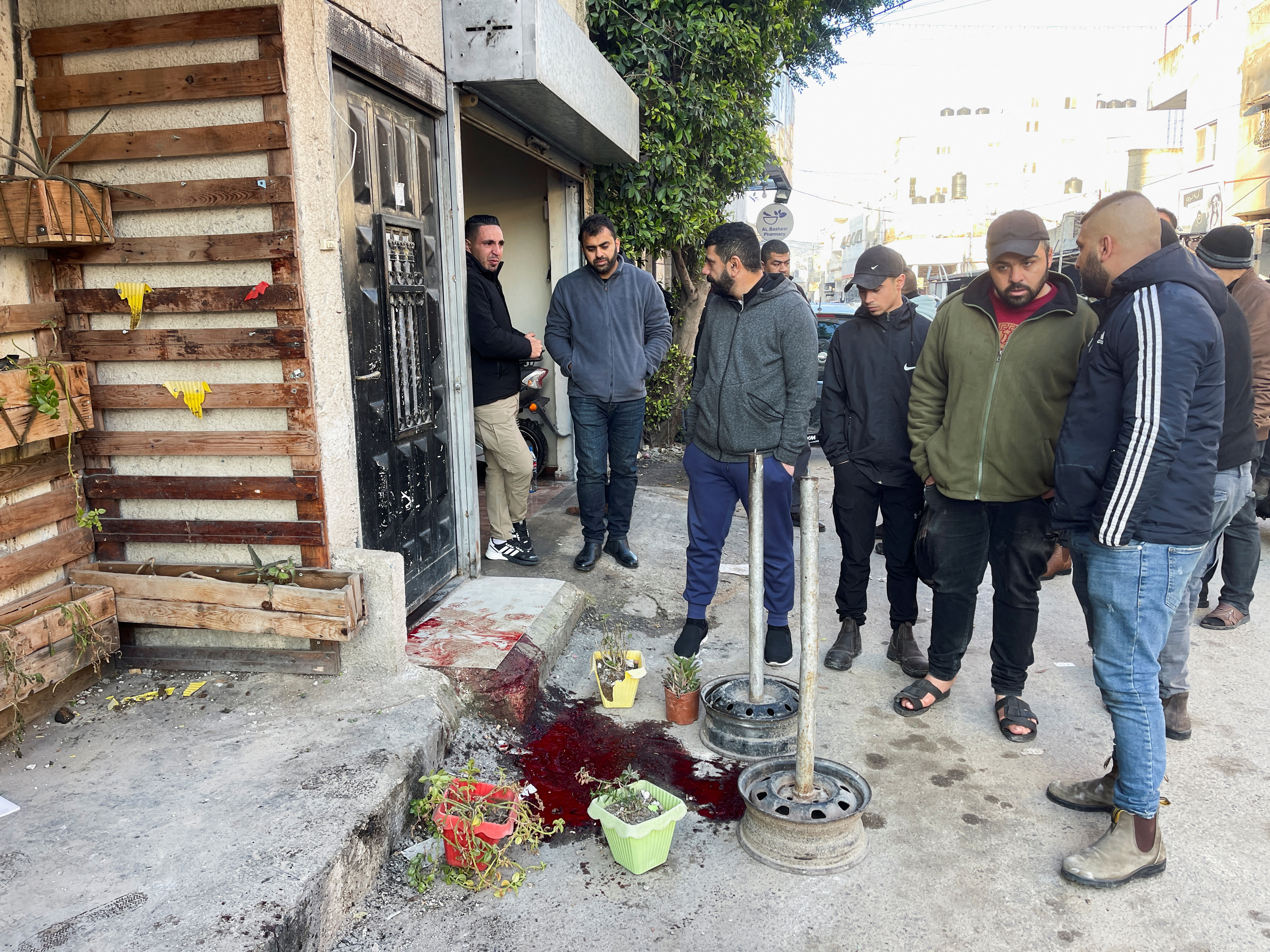 Palestinians gather outside the house of 57-year-old teacher Jawad Bouaqneh, who was killed during an Israeli raid in Jenin refugee camp