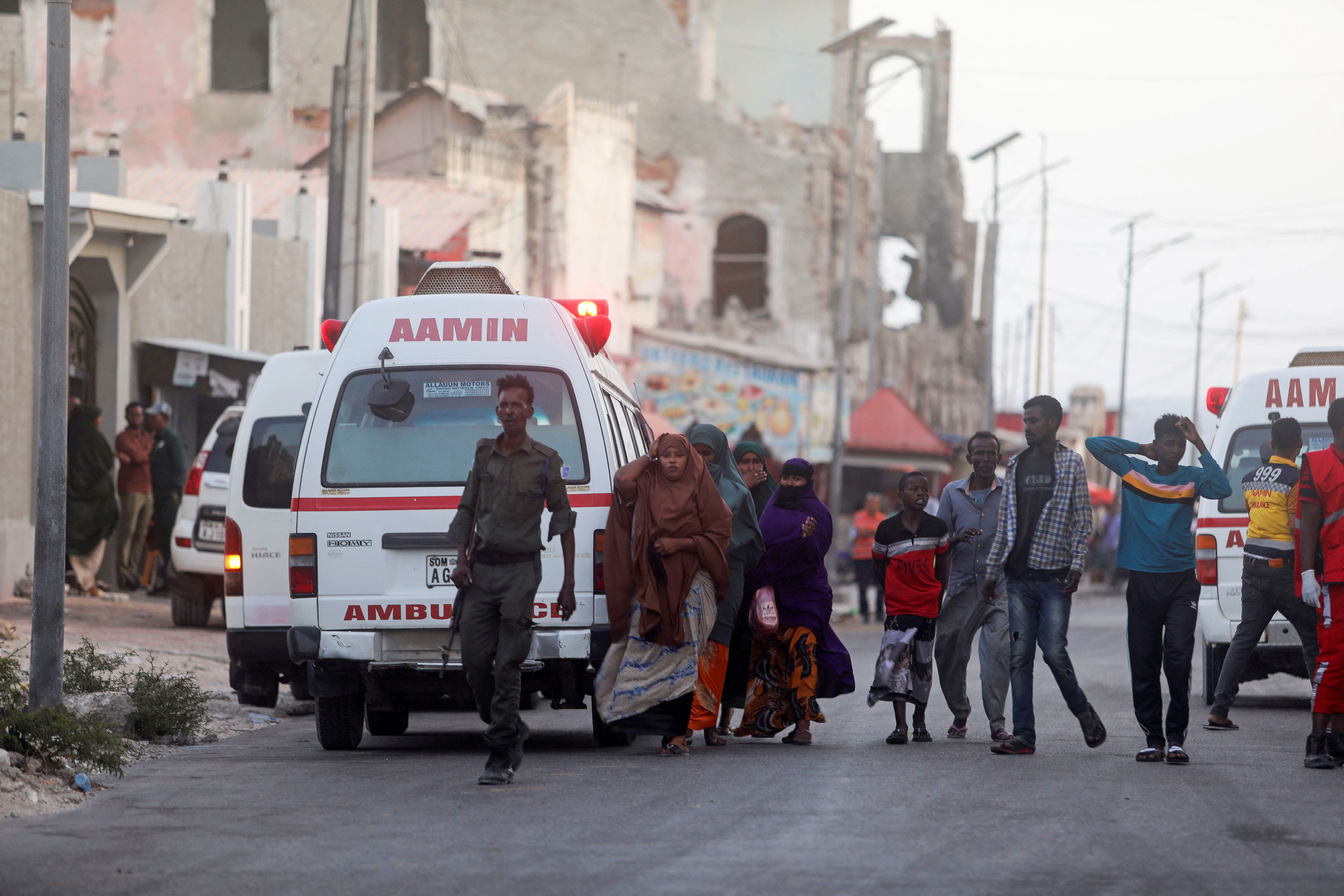 Somali security forces and civilians walk to view the bodies of suspected al Shabaab fighters killed in a clash with security members at the mayor's office