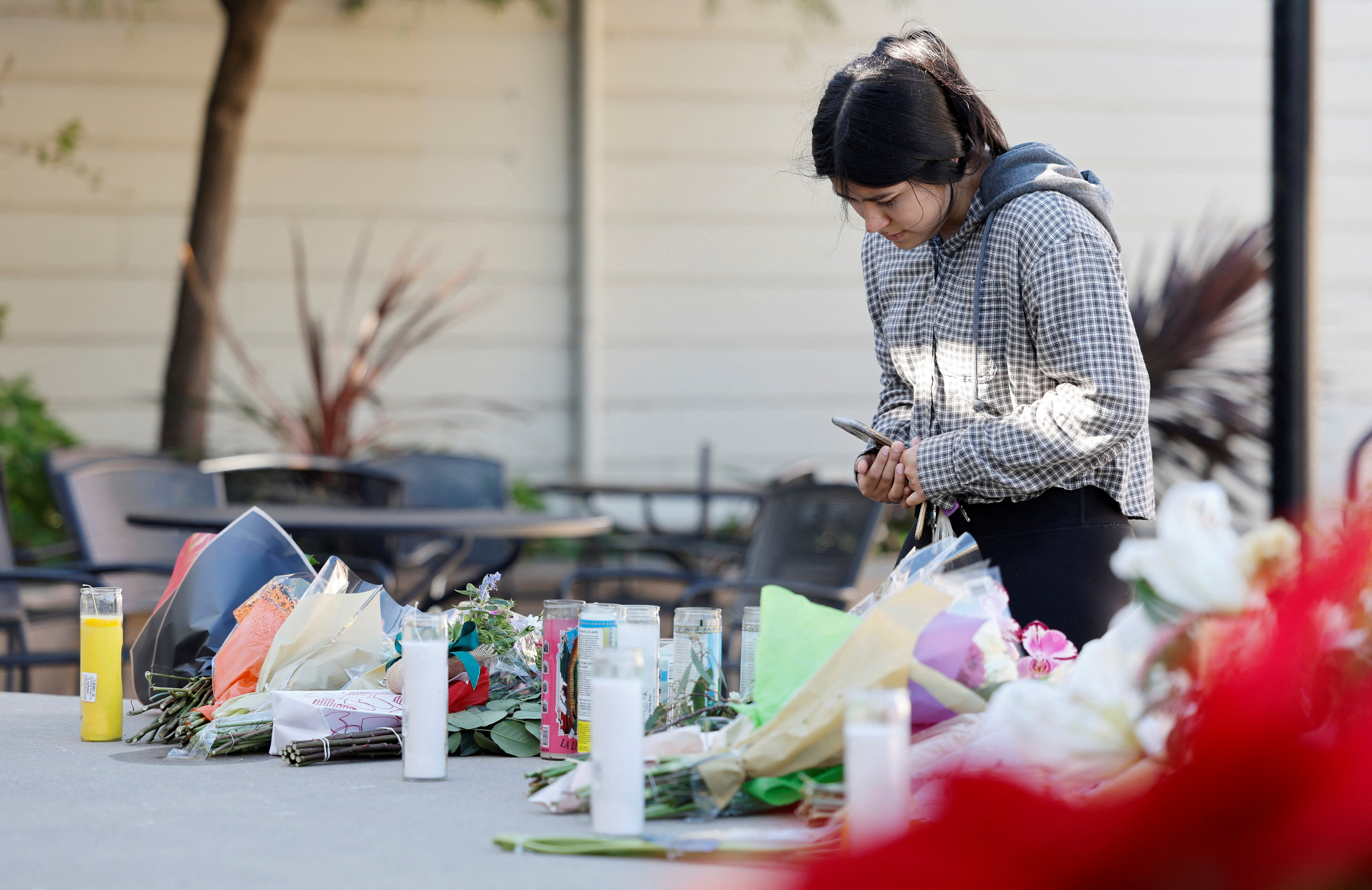 Half Moon Bay resident Susana Gutierrez visits a memorial for shooting victims at Mac Dutra Park in Half Moon Bay, California.