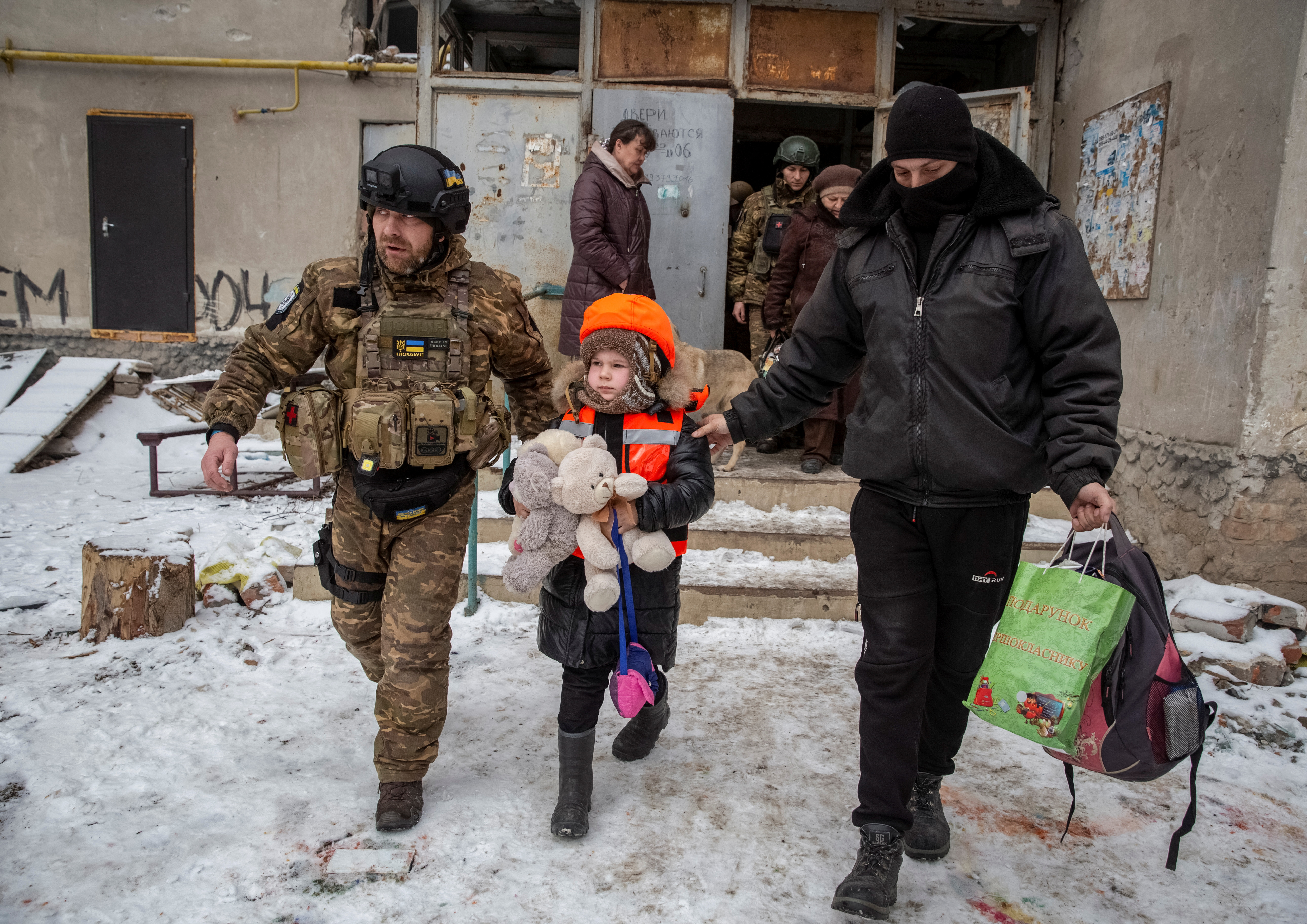 Ukrainian sevicemen help a child leave Bakhmut
