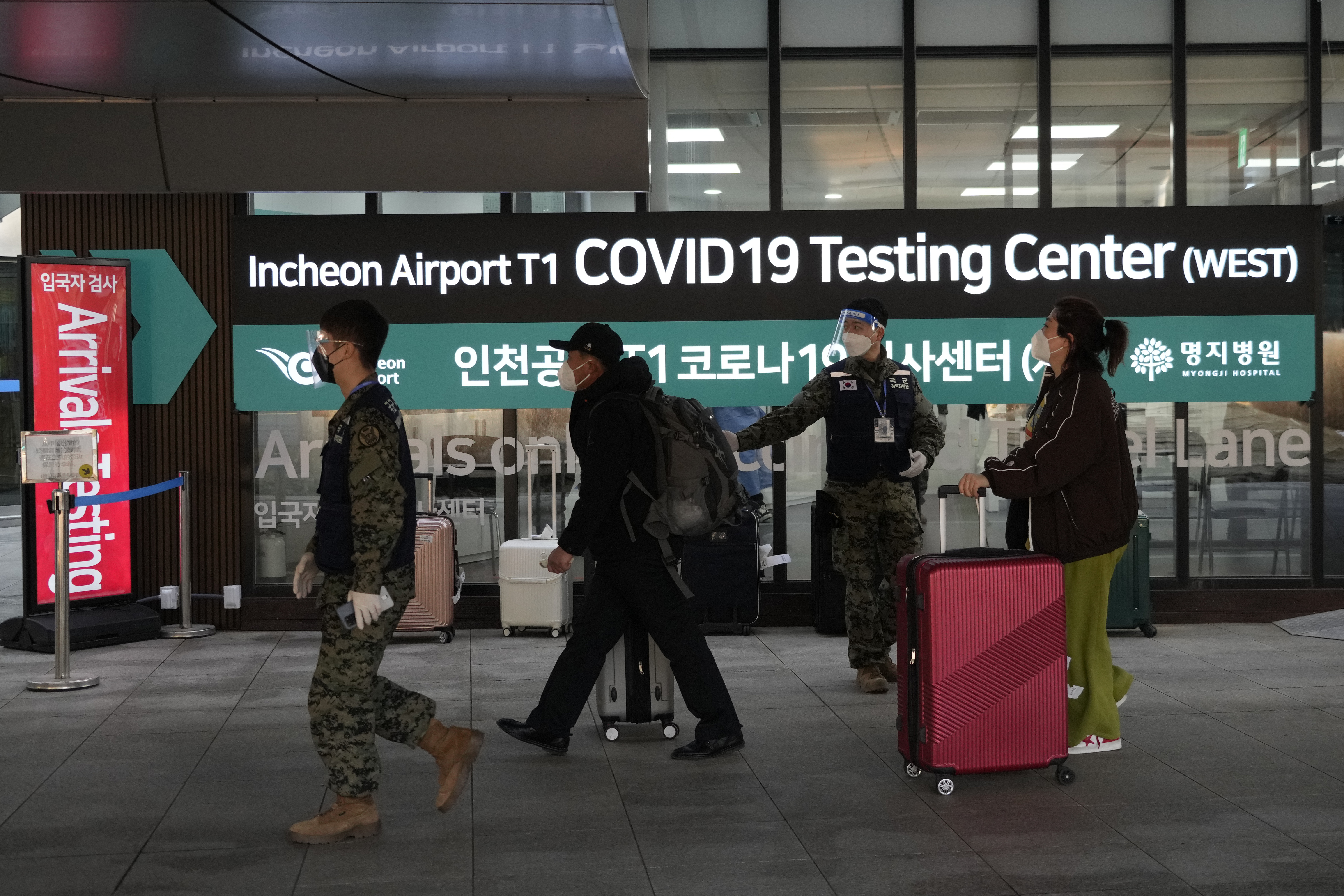 Passengers arriving from China pass by a COVID-19 testing centre at the Incheon International Airport in Incheon, South Korea.