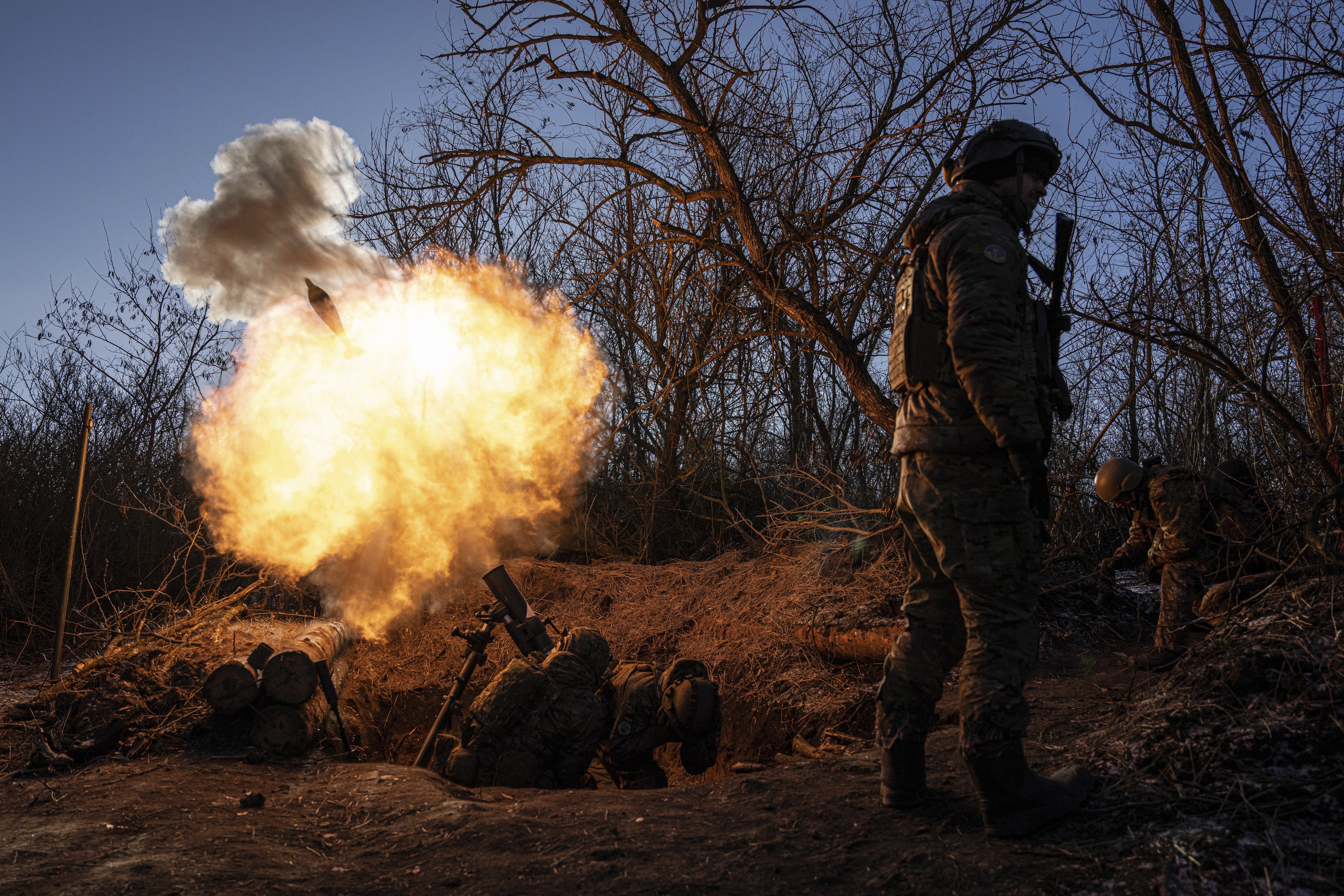 Ukrainian servicemen fire a 120mm mortar towards Russian positions at the frontline near Bakhmut, Donetsk region, Ukraine, Wednesday, Jan. 11, 2023. (AP Photo/Evgeniy Maloletka)