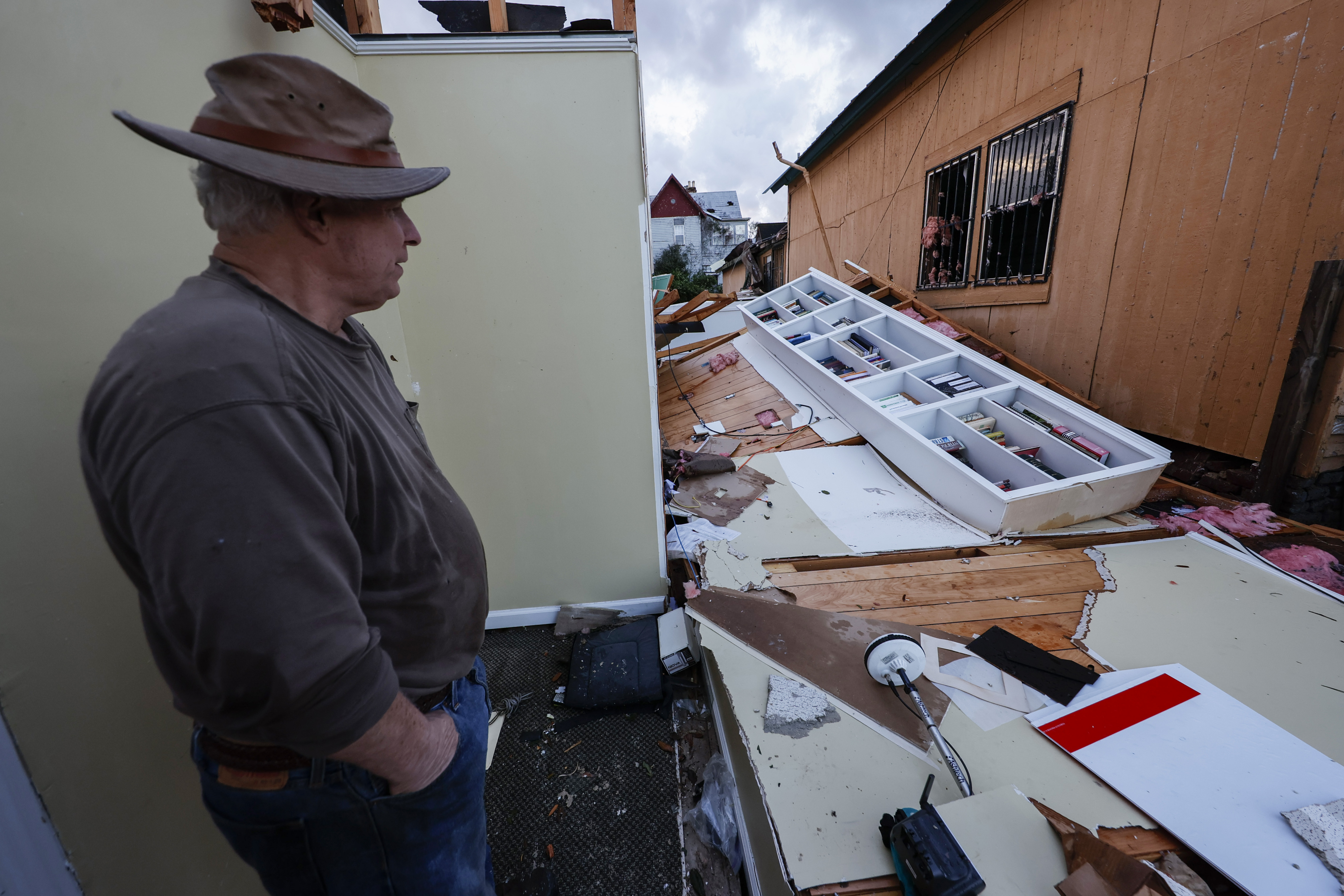 A man surveys the damage inflicted to his house after Thursday's tornadoes
