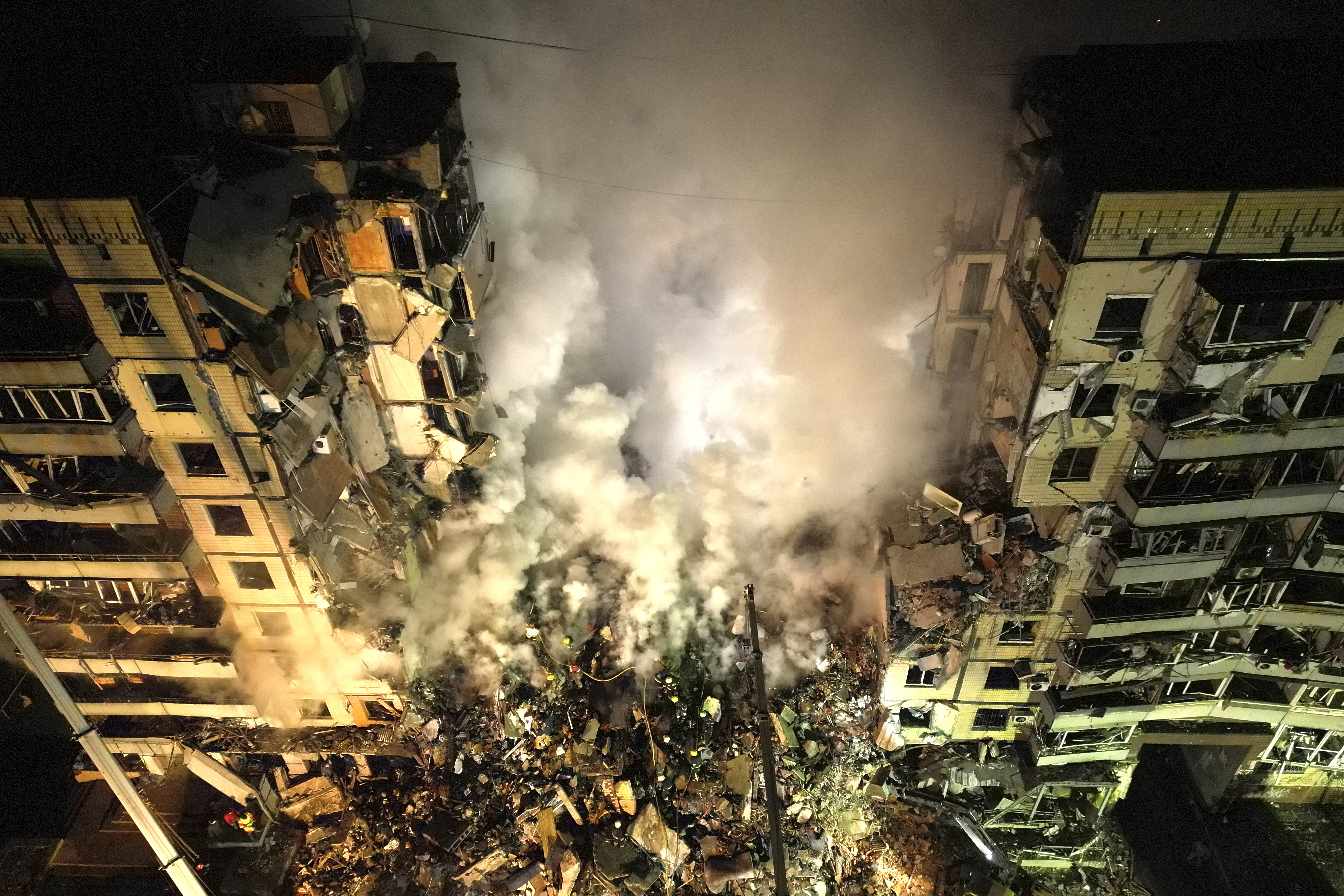 Emergency workers clear the rubble after a Russian rocket hit a multistory building leaving many people under debris in the southeastern city of Dnipro