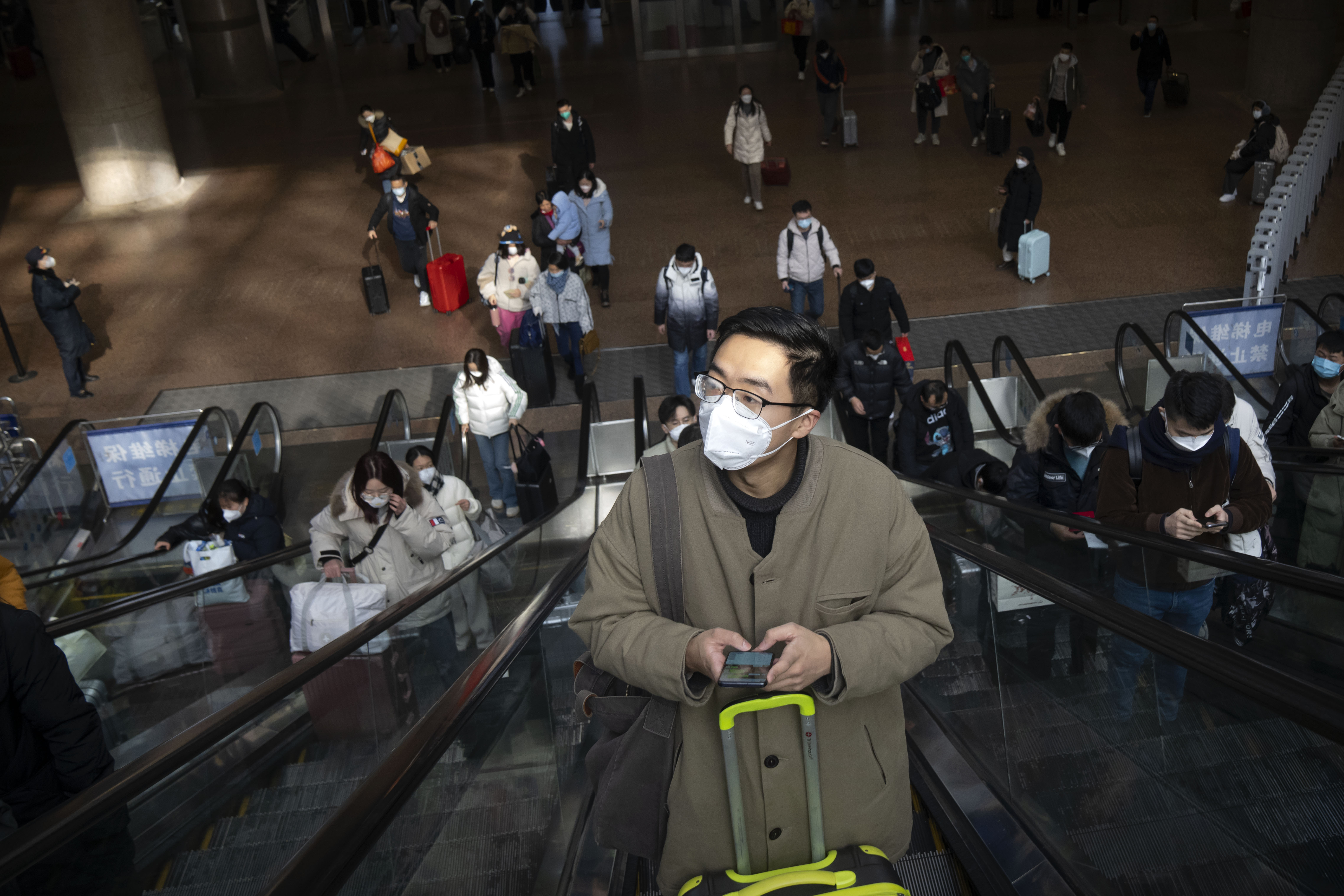 Travelers ride escalators at Beijing West Railway Station in Beijing,