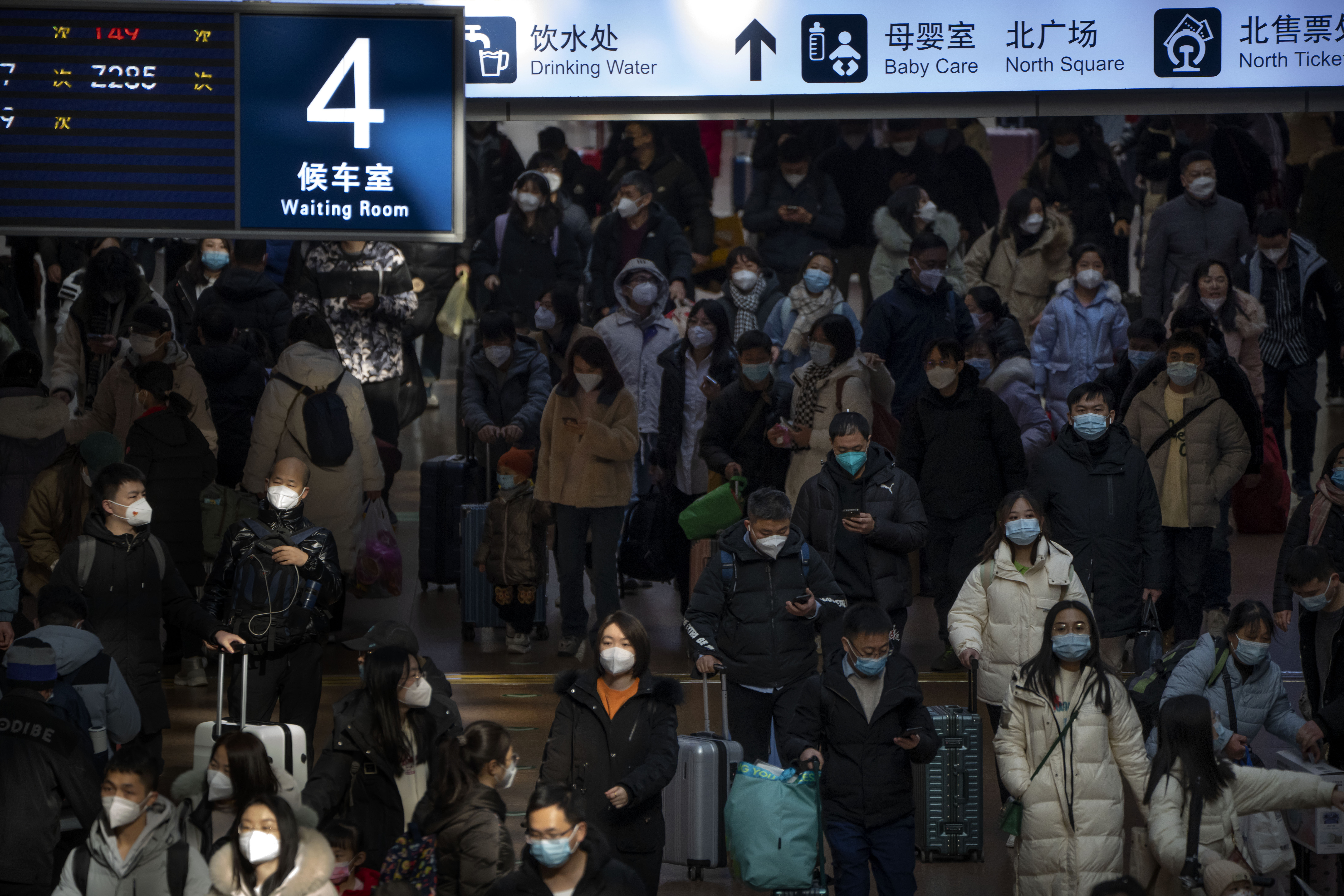 Travelers walk along a concourse at Beijing West Railway Station in Beijing