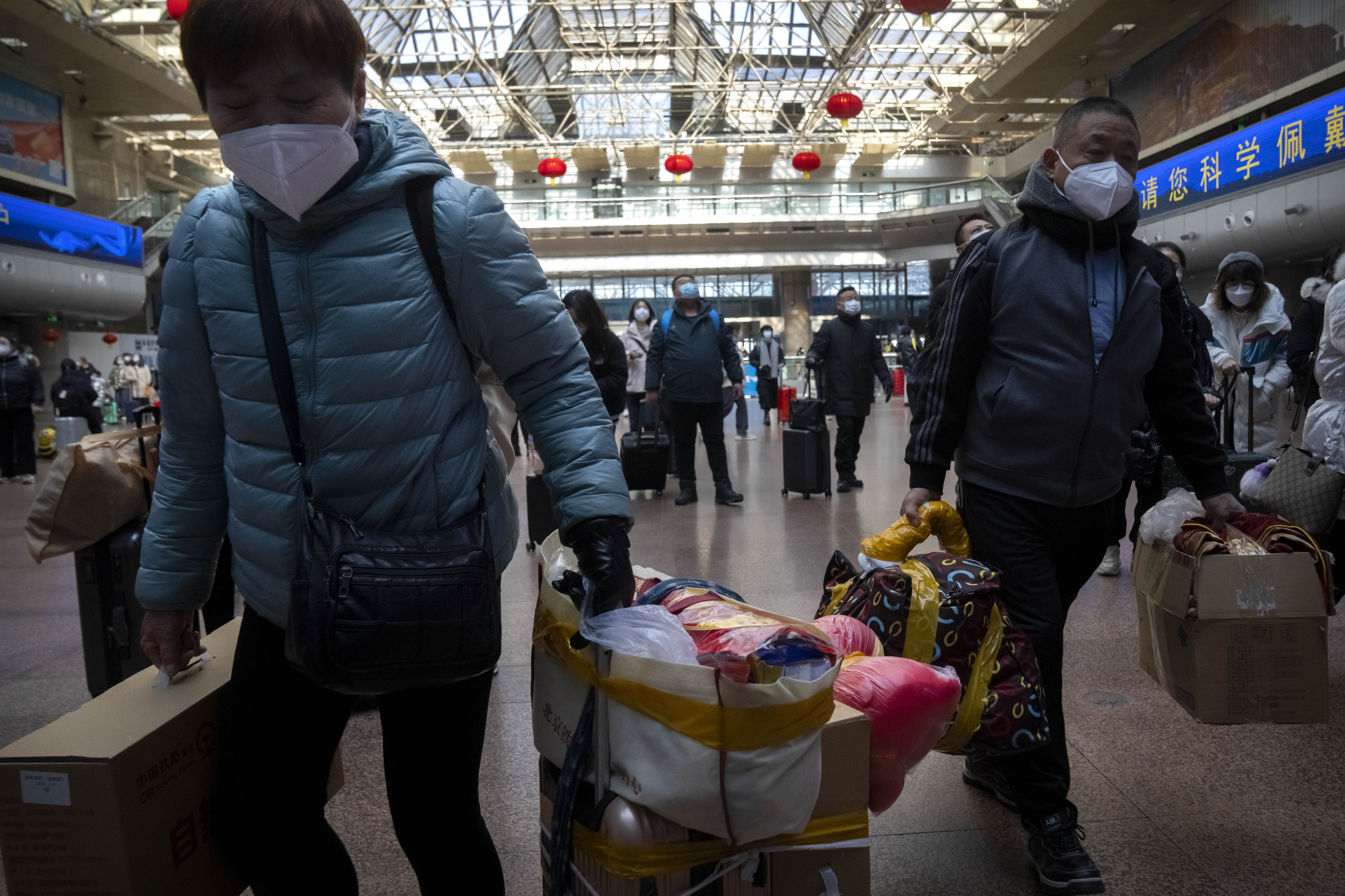 Travelers walk along a concourse at Beijing West Railway Station in Beijing