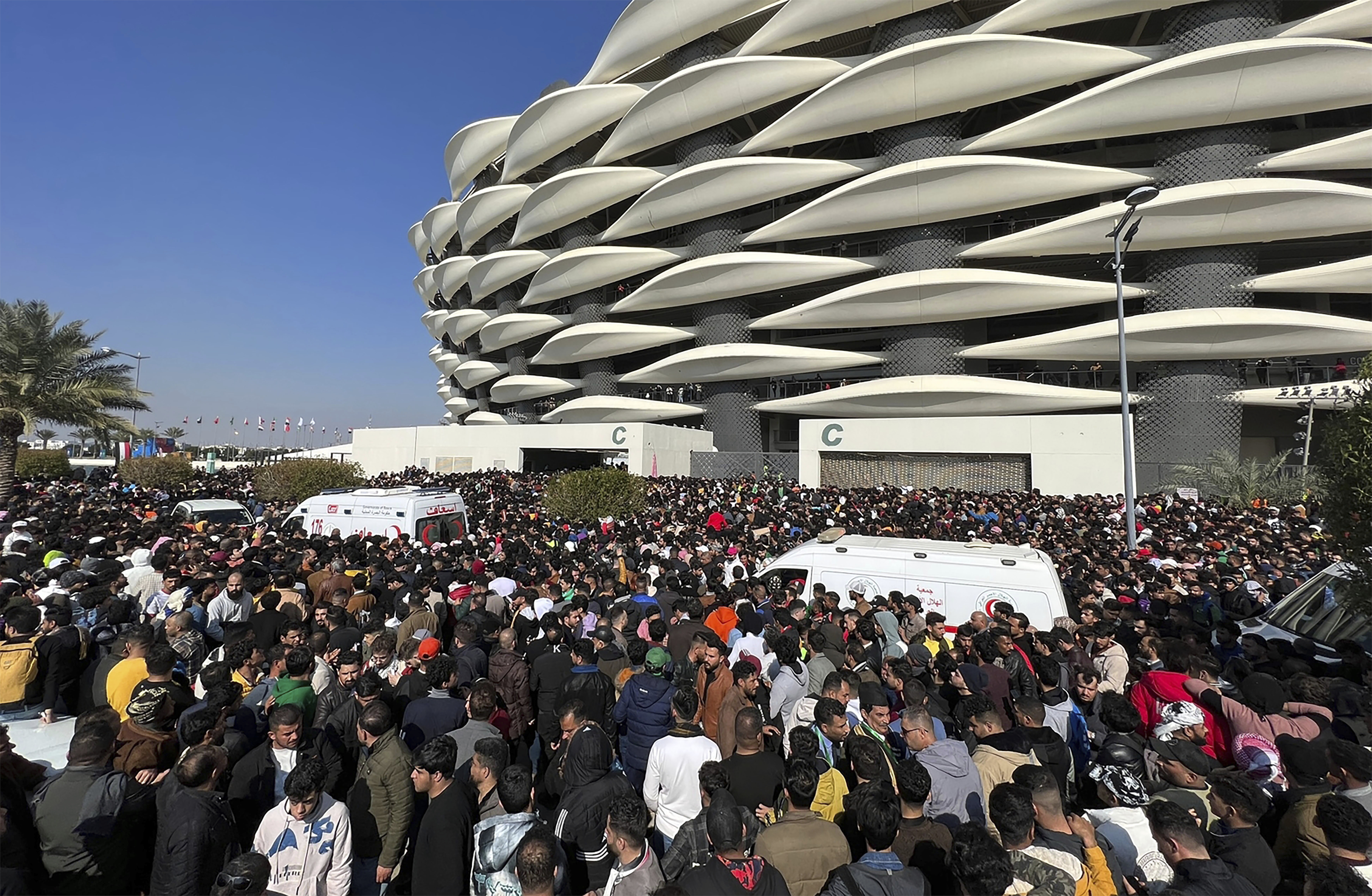 Iraqi soccer fans try to enter the Basra International Stadium in Basra, Iraq, Thursday, Jan 19, 2023. A stampede outside the stadium has killed and injured a number of people. (AP Photo/Anmar Khalil)