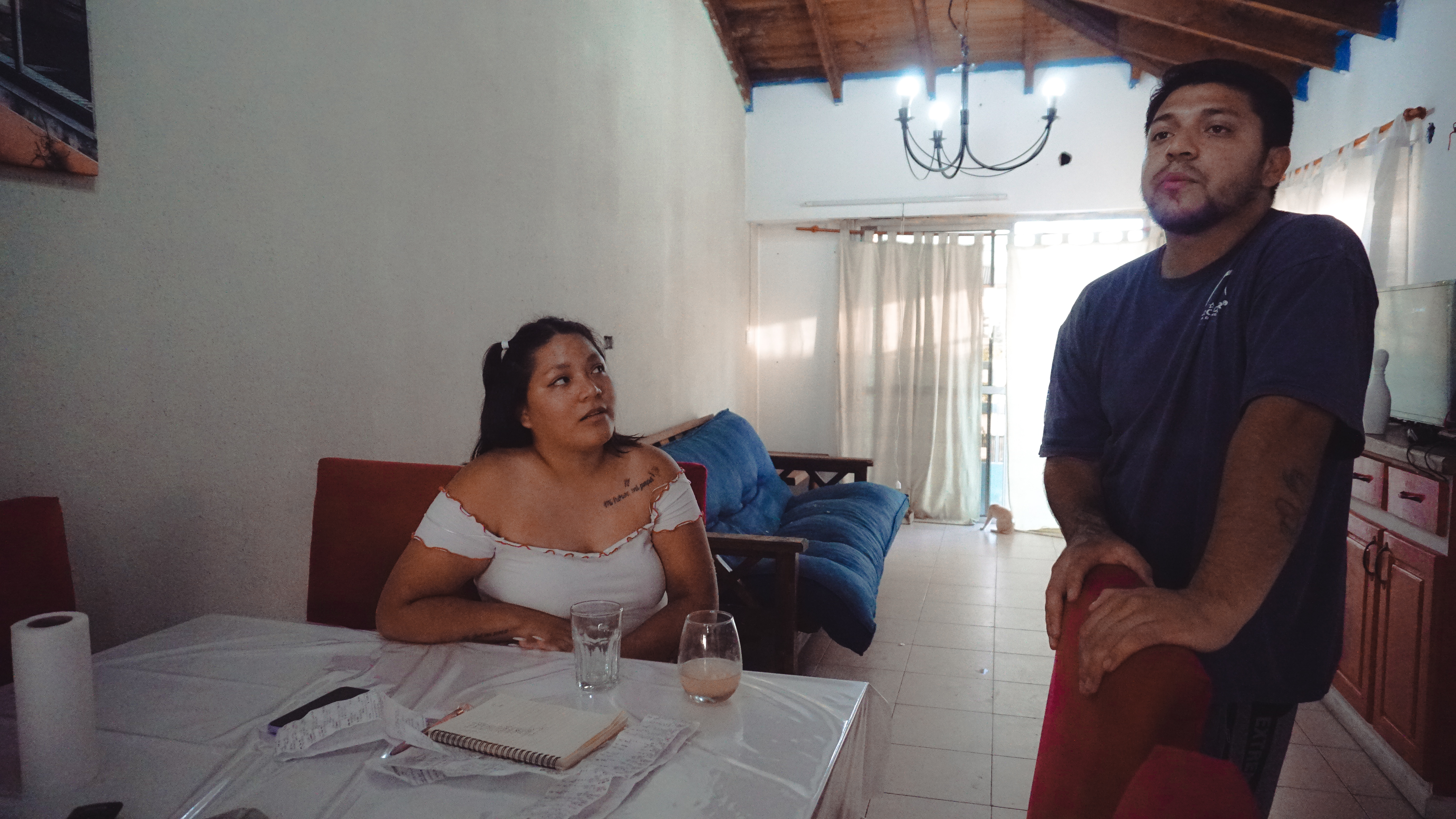 A photo of a woman sitting and looking at a man standing next to her.